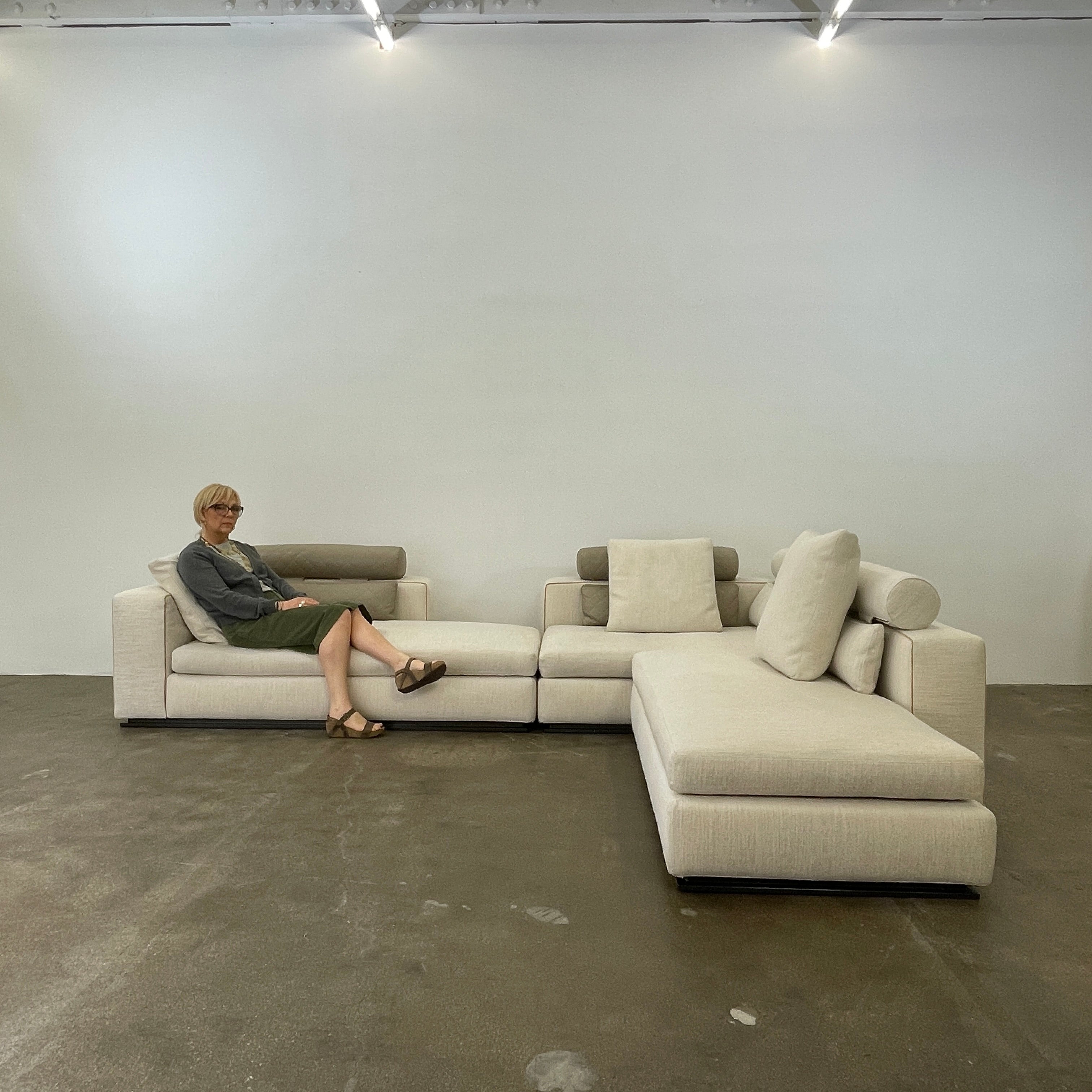 The Minotti Leonard 3 Piece Sectional by Minotti features an L-shaped beige design with three seat sections, multiple back and side cushions, and a right-side chaise lounge—ideal for an elegant living space—shown on a plain white background.