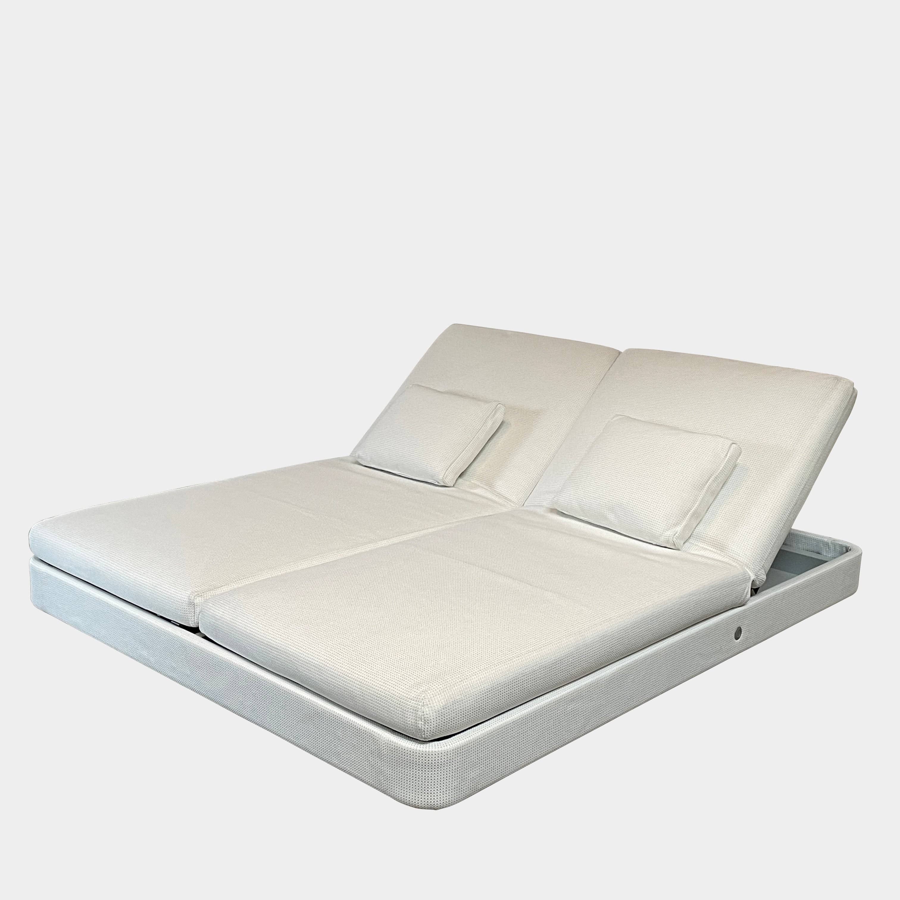 An adjustable white Paola Lenti Cove Double Sunbed by Paola Lenti features two separate reclining mattresses and matching pillows, perfect for outdoor lounging.