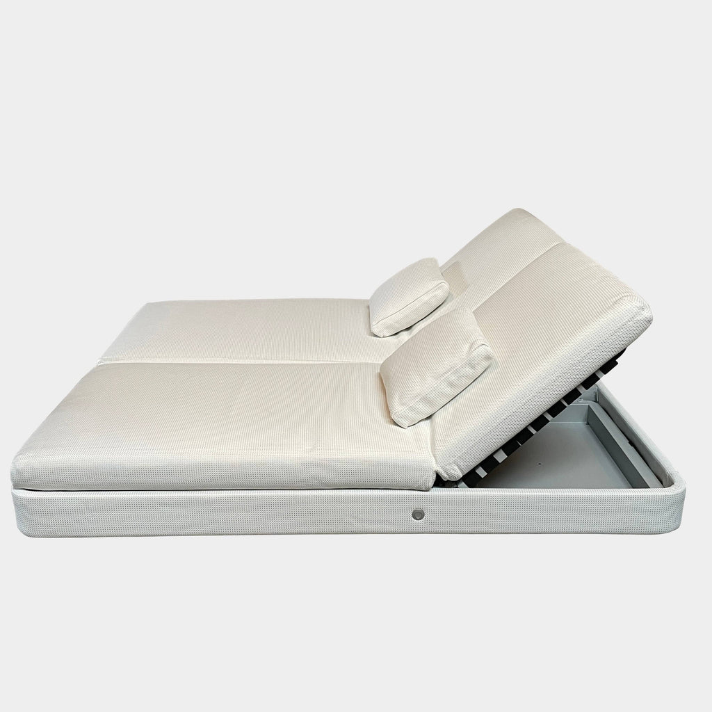 A Paola Lenti Cove Double Sunbed, in white, with two pillows on top of it.