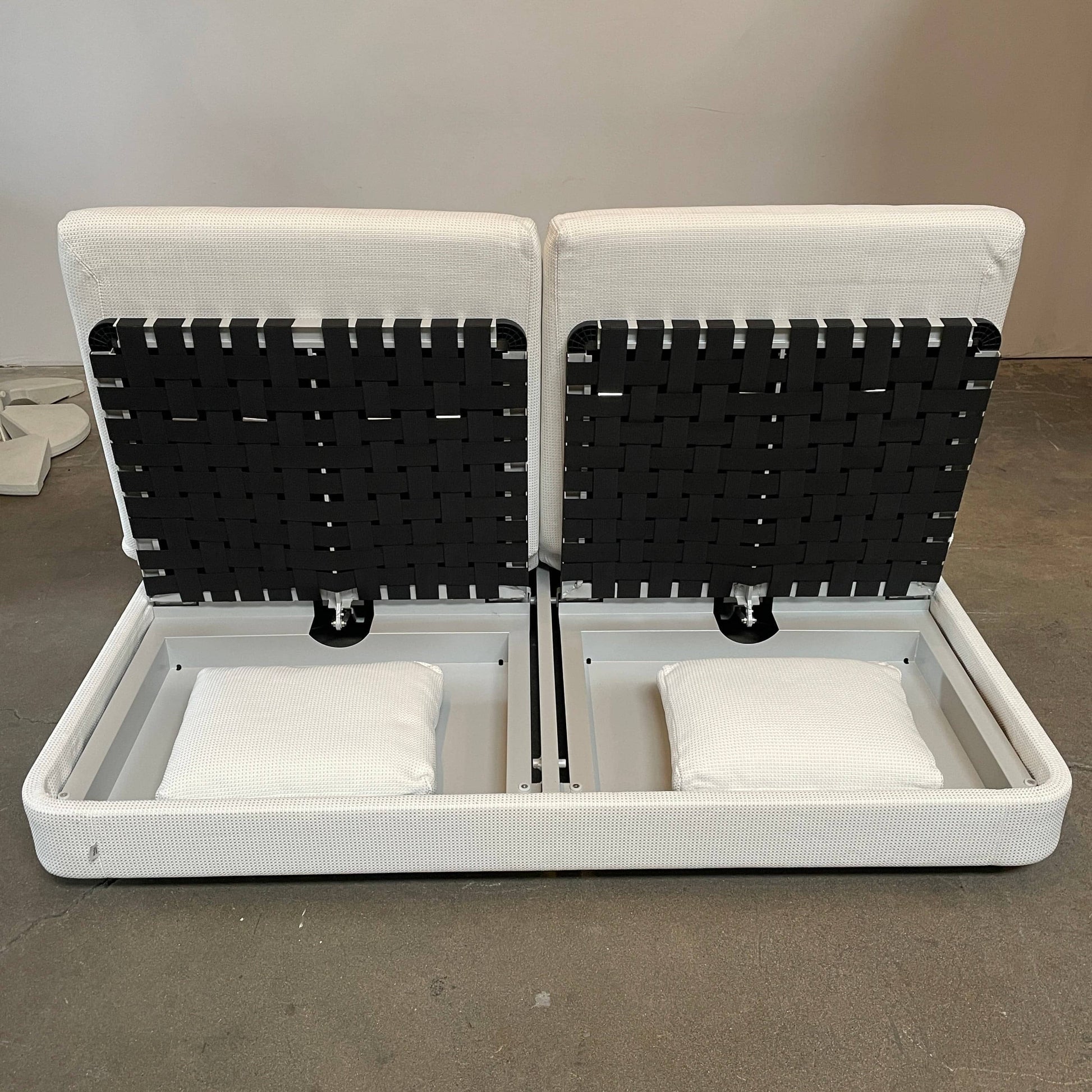 An adjustable white Paola Lenti Cove Double Sunbed by Paola Lenti features two separate reclining mattresses and matching pillows, perfect for outdoor lounging.