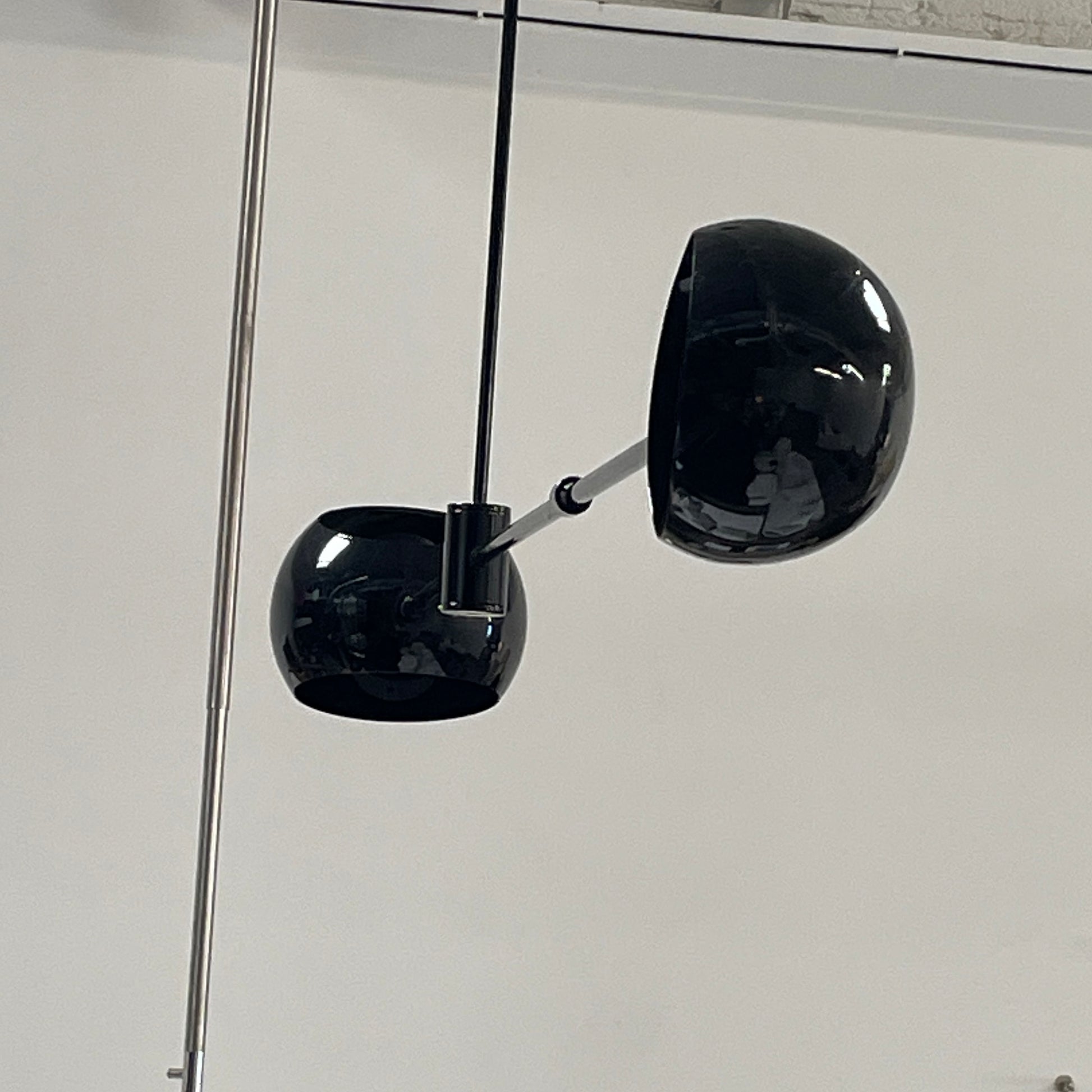 The David Weeks Studio Abaca Suspension Light is a custom-made, black, modern hanging fixture with two spherical bulbs. Crafted from powder-coated steel, it elegantly suspends from ceilings with exposed beams to add sophistication to any space.