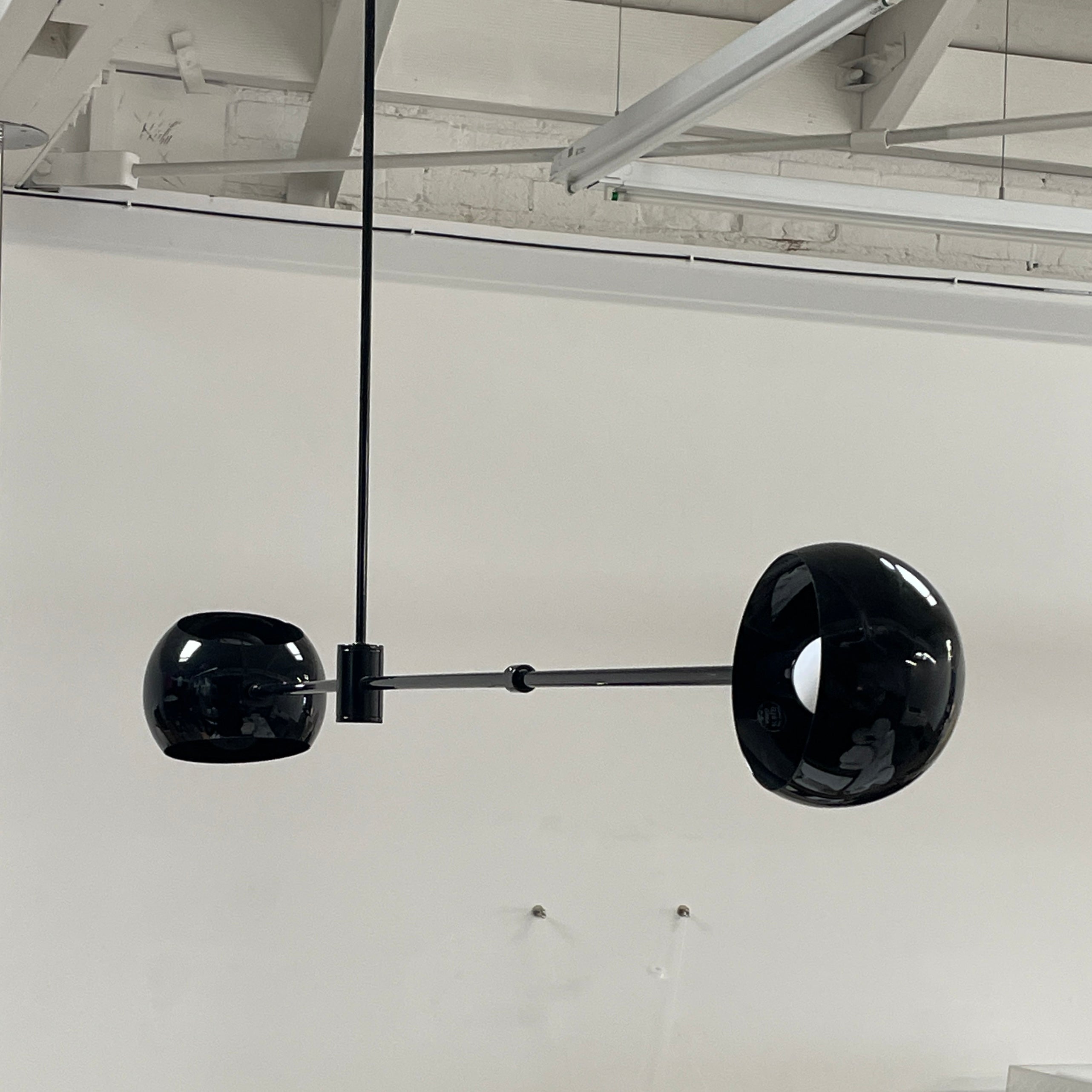 The David Weeks Studio Abaca Suspension Light is a custom-made, black, modern hanging fixture with two spherical bulbs. Crafted from powder-coated steel, it elegantly suspends from ceilings with exposed beams to add sophistication to any space.
