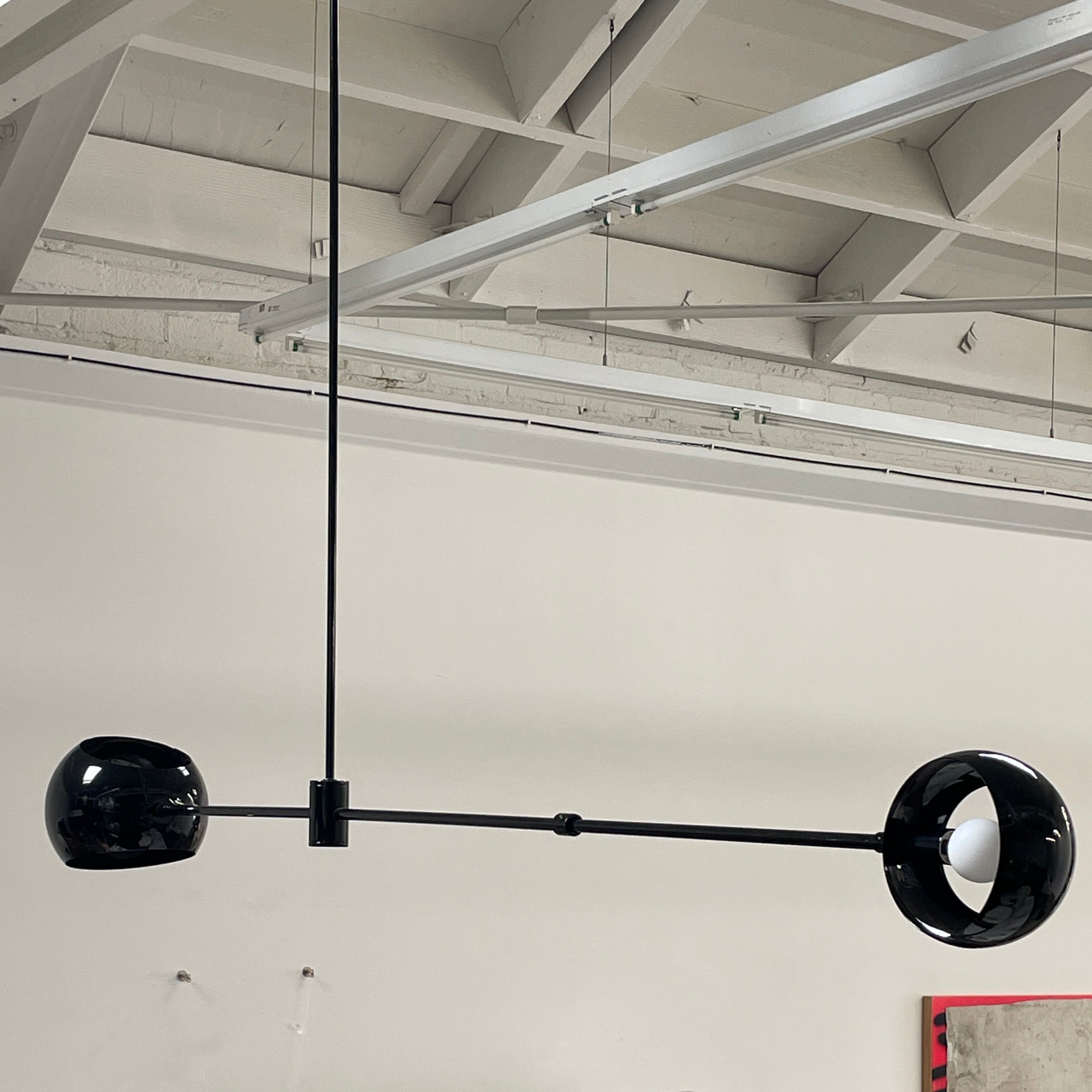 The David Weeks Studio Abaca Suspension Light is a custom-made, black, modern hanging fixture with two spherical bulbs. Crafted from powder-coated steel, it elegantly suspends from ceilings with exposed beams to add sophistication to any space.