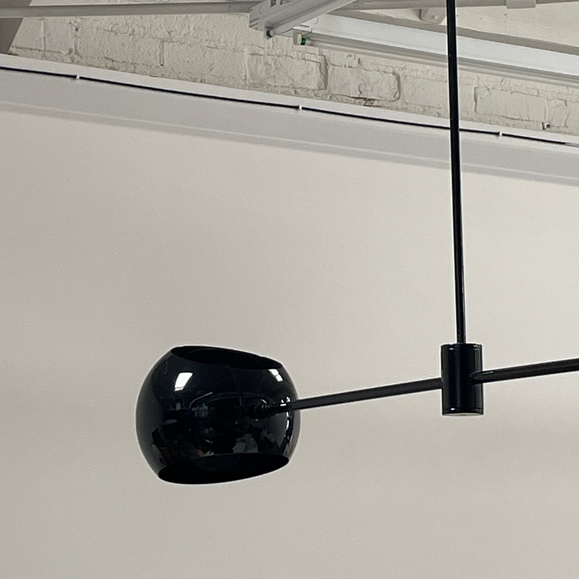 The David Weeks Studio Abaca Suspension Light is a custom-made, black, modern hanging fixture with two spherical bulbs. Crafted from powder-coated steel, it elegantly suspends from ceilings with exposed beams to add sophistication to any space.