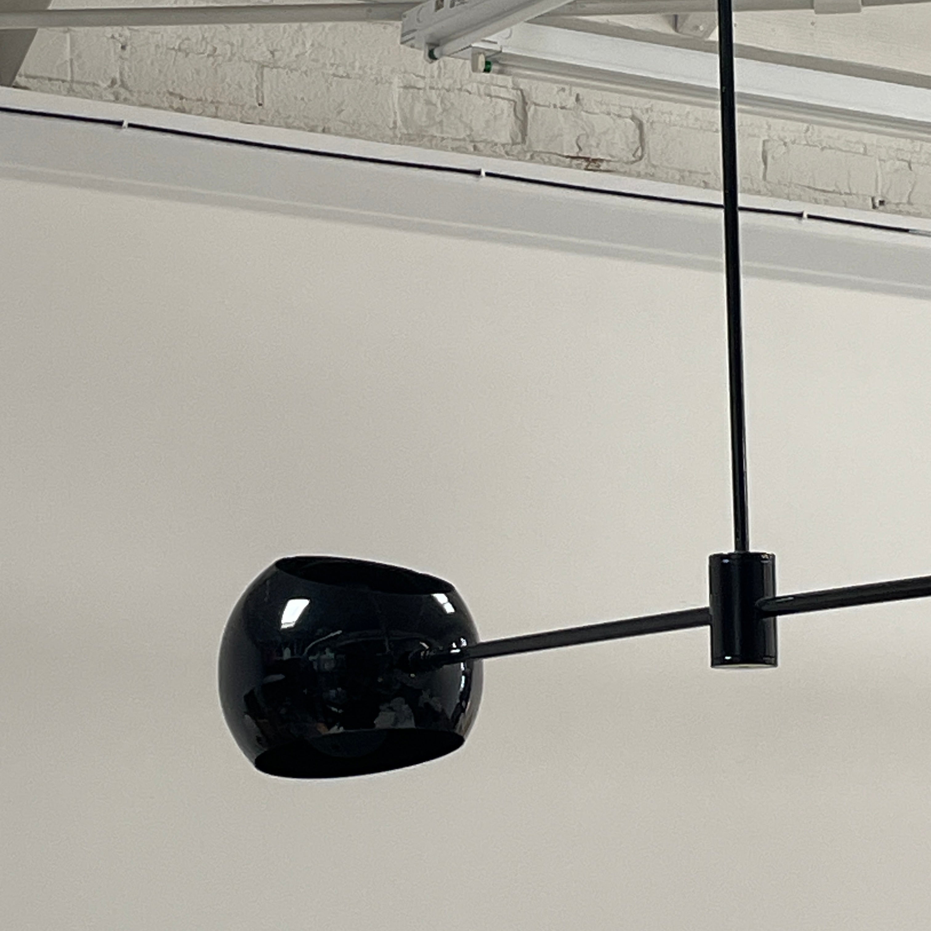 The David Weeks Studio Abaca Suspension Light is a custom-made, black, modern hanging fixture with two spherical bulbs. Crafted from powder-coated steel, it elegantly suspends from ceilings with exposed beams to add sophistication to any space.