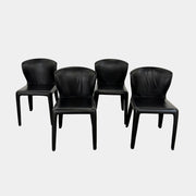 A set of four Cassina Hola Dining Chairs by Cassina, upholstered in black leather, are set in two rows against a plain white background.