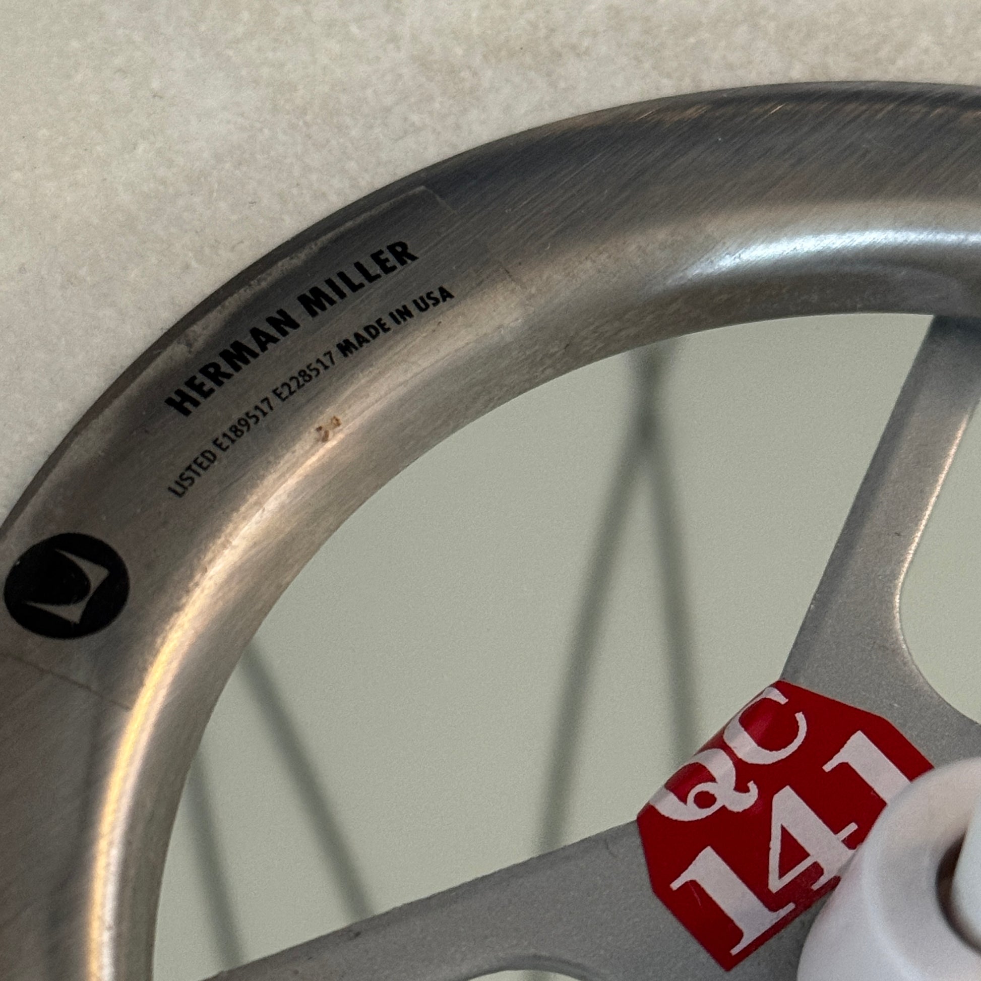 A medium Herman Miller Nelson Saucer Crisscross Bubble Pendant in white hangs before a wooden slat partition and beige sofa.