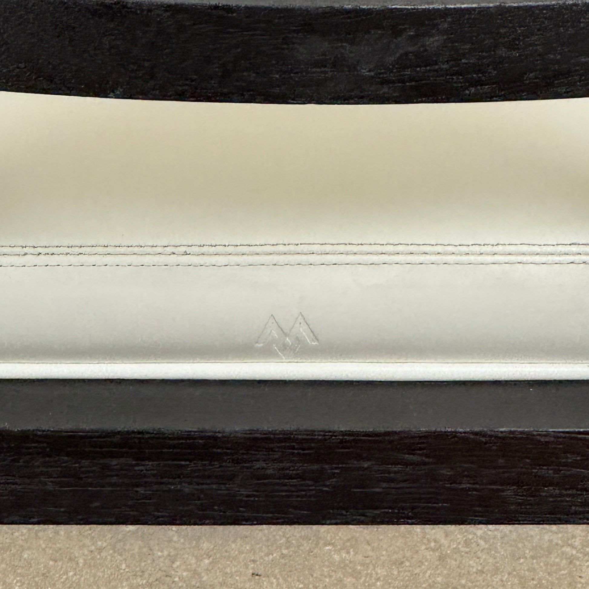 A Maxalto Teti Dining Chair from a set of 6, featuring a black frame with white upholstered seat and backrest, stands on a brown concrete floor against a plain light gray wall.