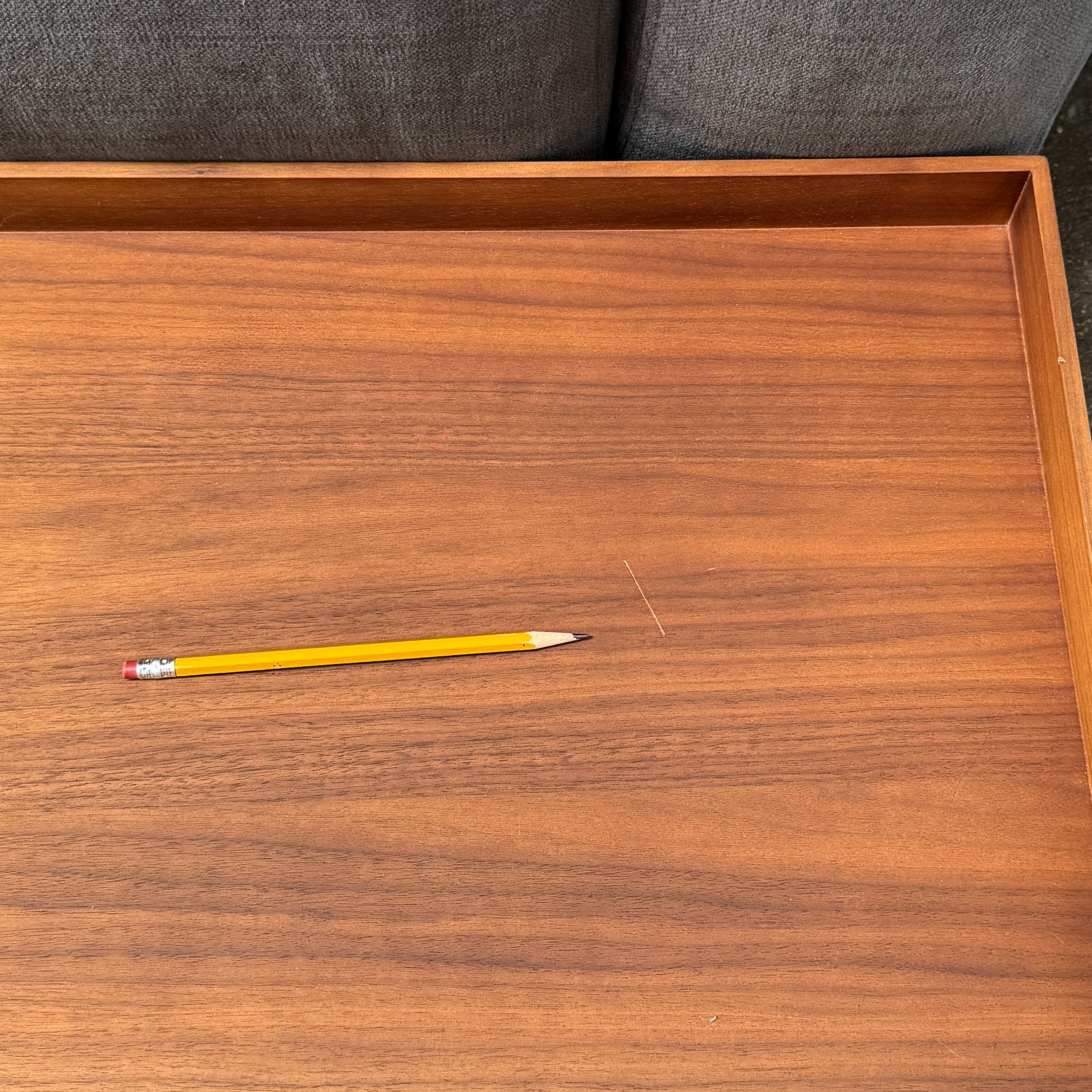 The Cassina Mex Hi Modular Sofa by Cassina features dark gray recycled fiber upholstery, metal legs, multiple cushions, and an integrated wooden side table, shown against a white background.
