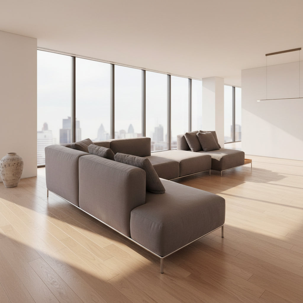 The Cassina Mex Hi Modular Sofa by Cassina features dark gray recycled fiber upholstery, metal legs, multiple cushions, and an integrated wooden side table, shown against a white background.