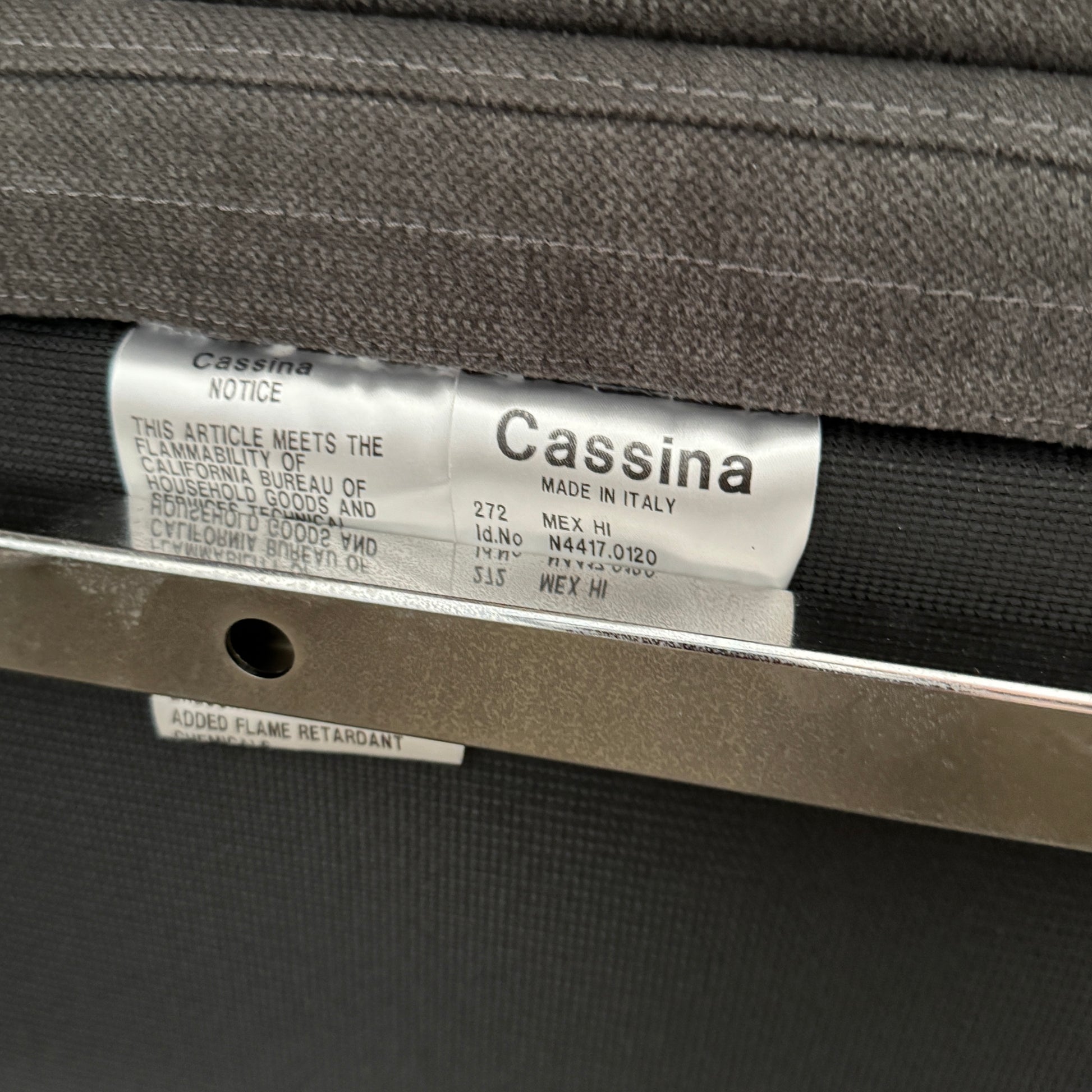 The Cassina Mex Hi Modular Sofa by Cassina features dark gray recycled fiber upholstery, metal legs, multiple cushions, and an integrated wooden side table, shown against a white background.