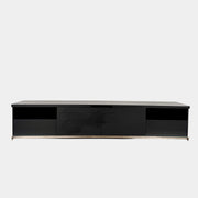 The Maxalto Mida Console by Maxalto is a modern black sideboard TV stand with three closed cabinets and two open shelves, shown on a concrete floor against a plain white background.