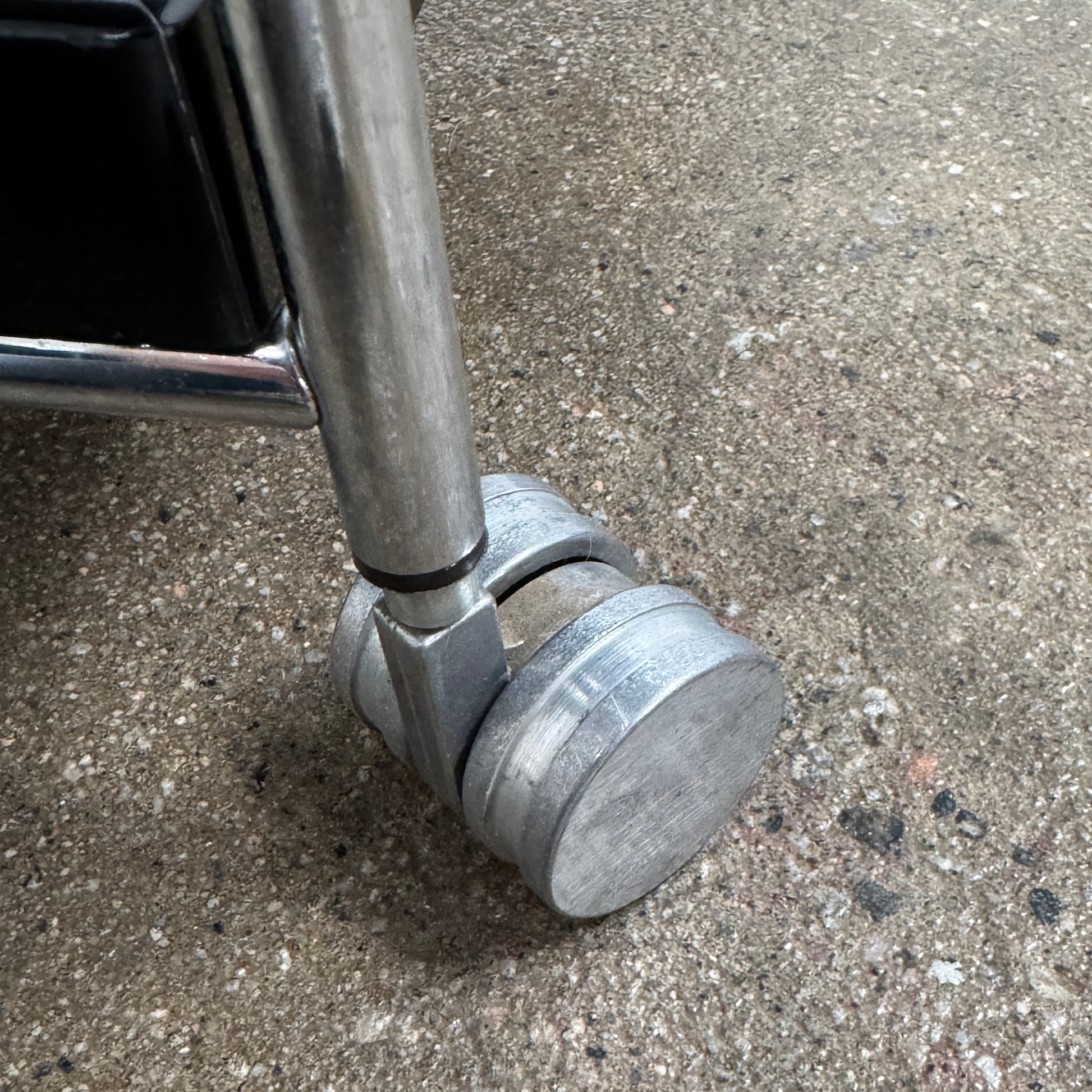 The Kartell Trays Trolly by Kartell features three black metal tiers, glass shelves, and four wheels, displayed on a plain white background.