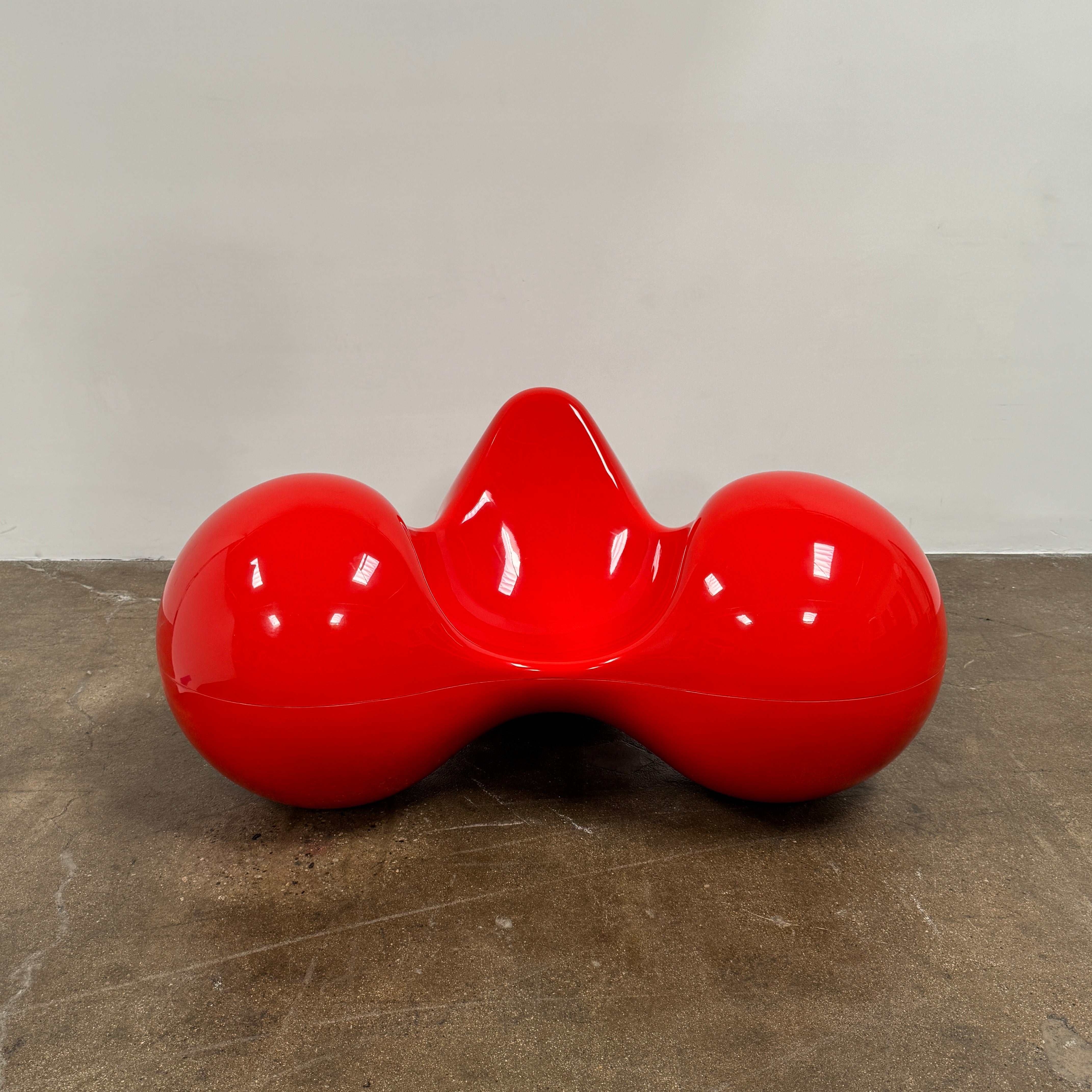 The Eero Aarnio Originals Tomato Chair by Eero Aarnio Originals is a glossy red modern plastic chair with three rounded, connected sections, inspired by the original design and shown against a plain white background.