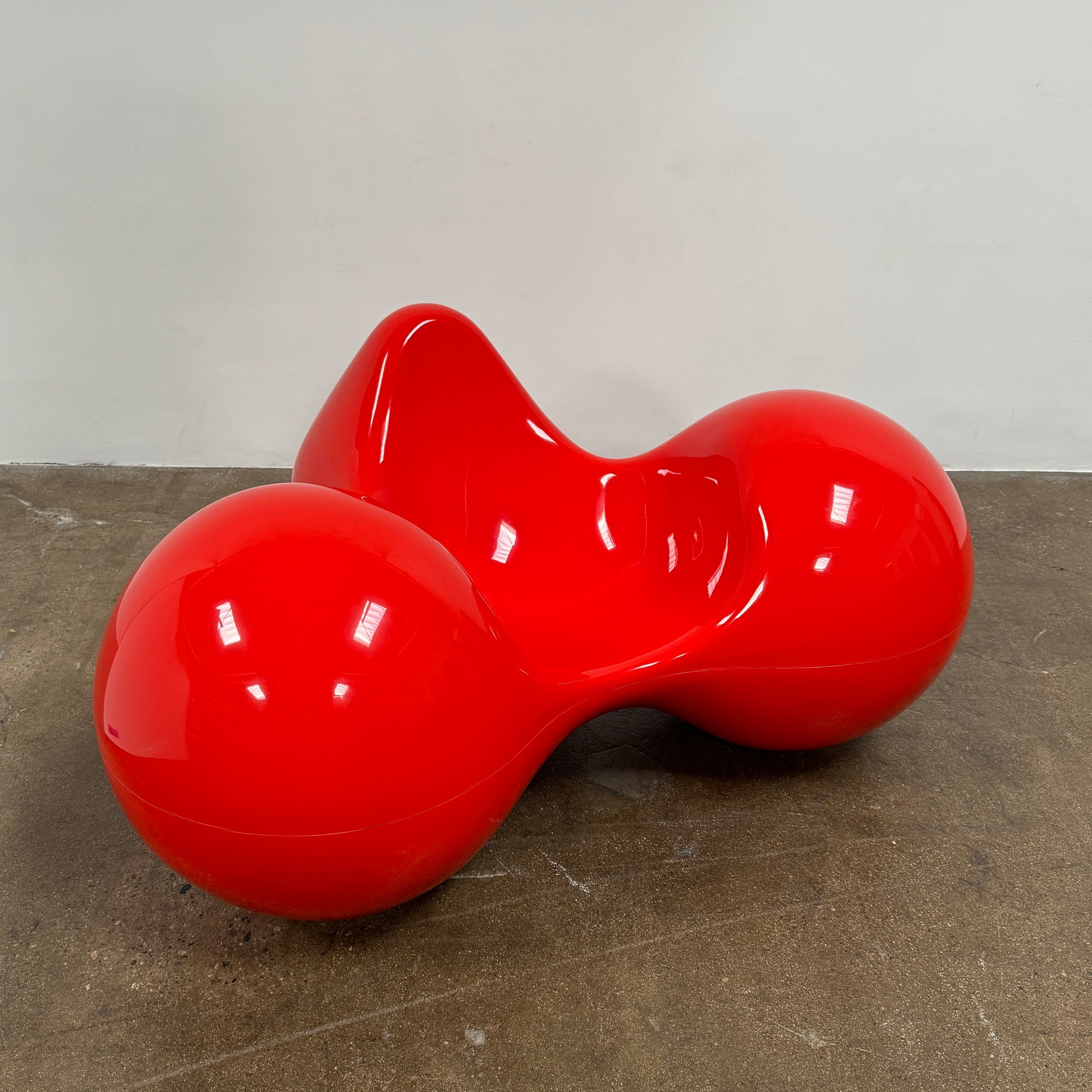 The Eero Aarnio Originals Tomato Chair by Eero Aarnio Originals is a glossy red modern plastic chair with three rounded, connected sections, inspired by the original design and shown against a plain white background.
