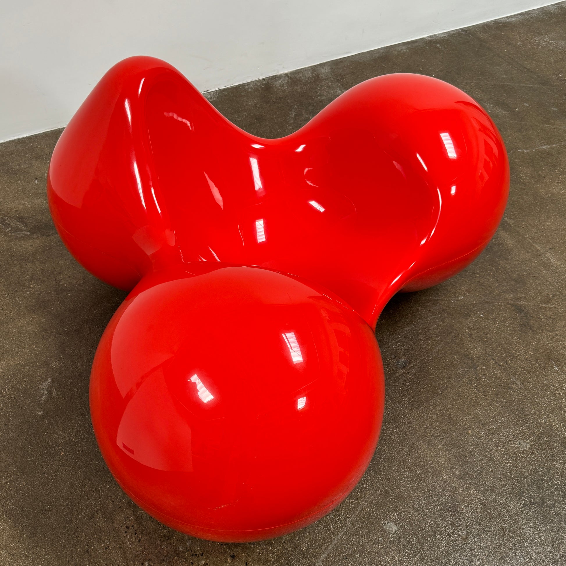 The Eero Aarnio Originals Tomato Chair by Eero Aarnio Originals is a glossy red modern plastic chair with three rounded, connected sections, inspired by the original design and shown against a plain white background.