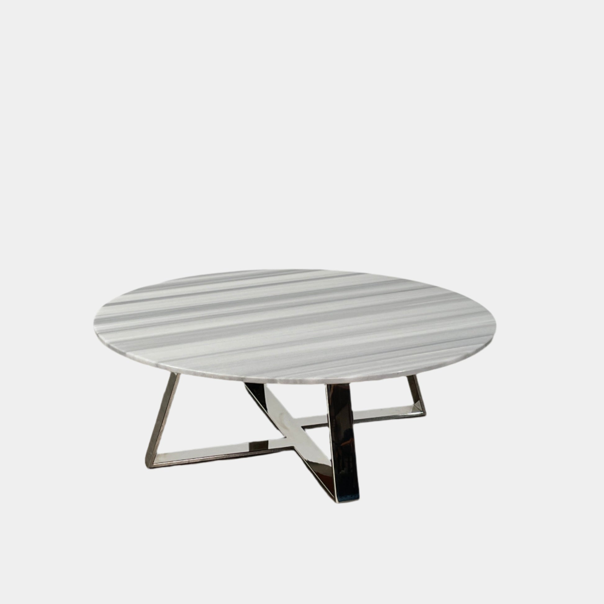 The Lievo Home Modern Studio Ingrid Coffee Table has a glossy marble top with white and gray stripes and a polished stainless steel base, shown on a bare concrete floor against a plain white wall.