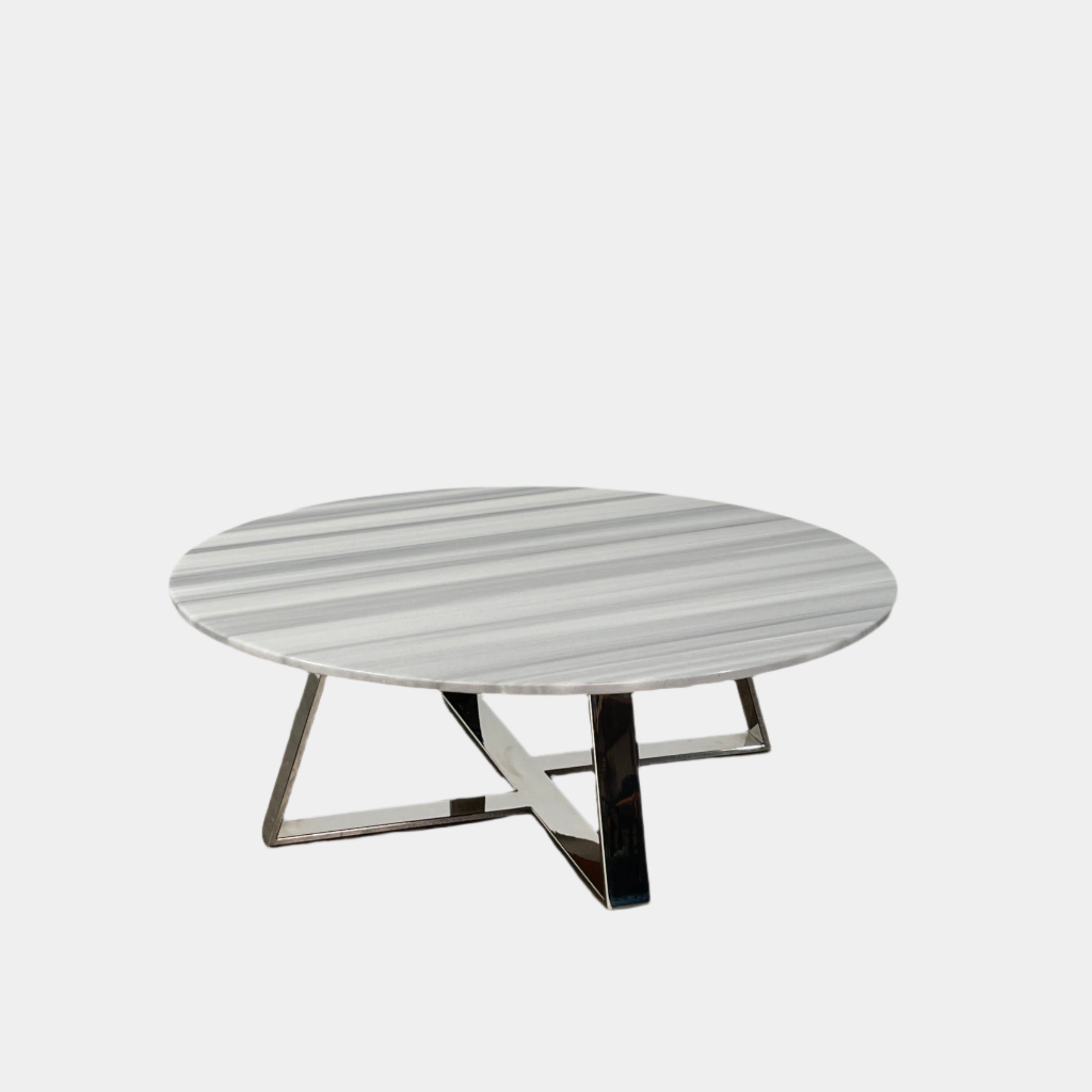 The Lievo Home Modern Studio Ingrid Coffee Table has a glossy marble top with white and gray stripes and a polished stainless steel base, shown on a bare concrete floor against a plain white wall.