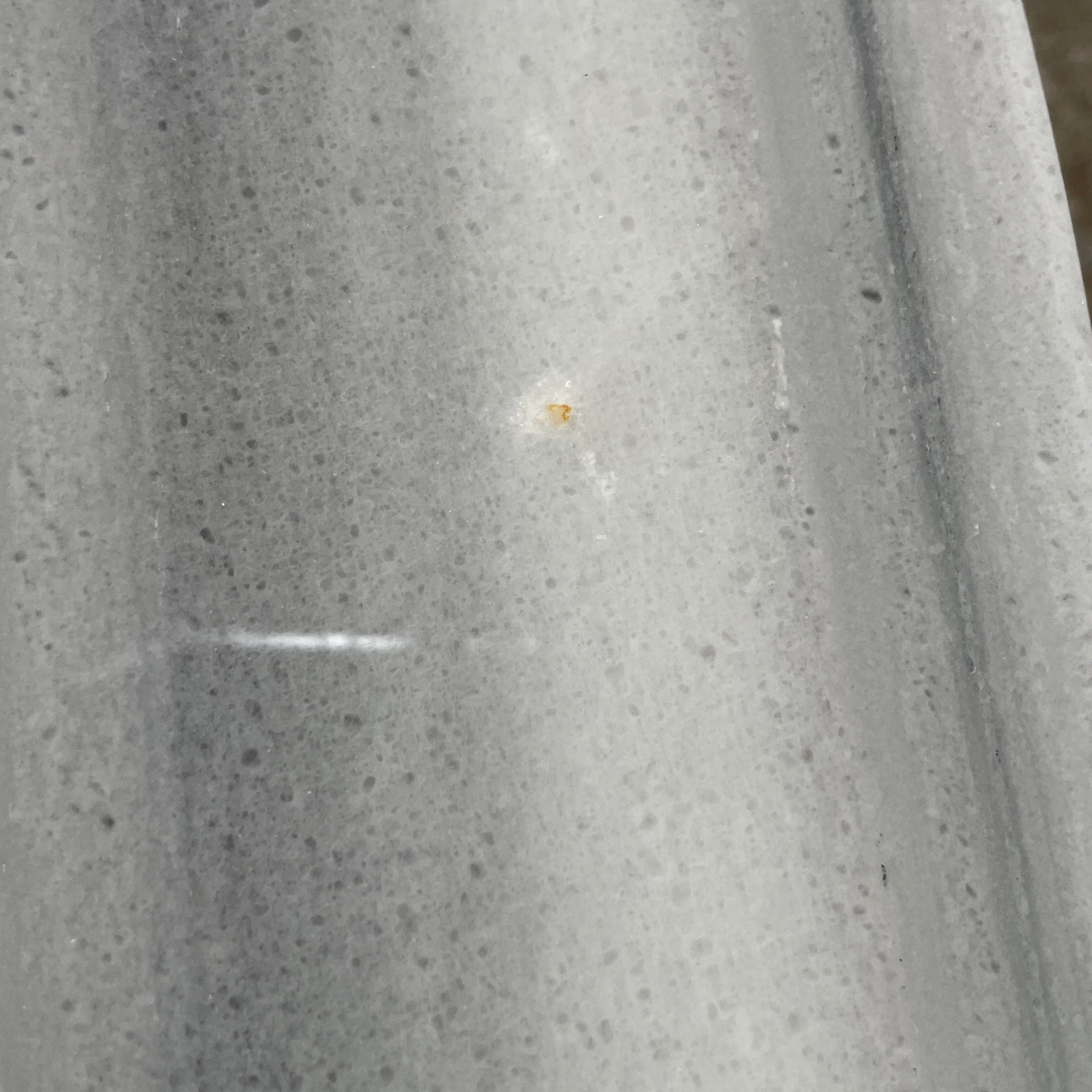 The Lievo Home Modern Studio Ingrid Coffee Table has a glossy marble top with white and gray stripes and a polished stainless steel base, shown on a bare concrete floor against a plain white wall.