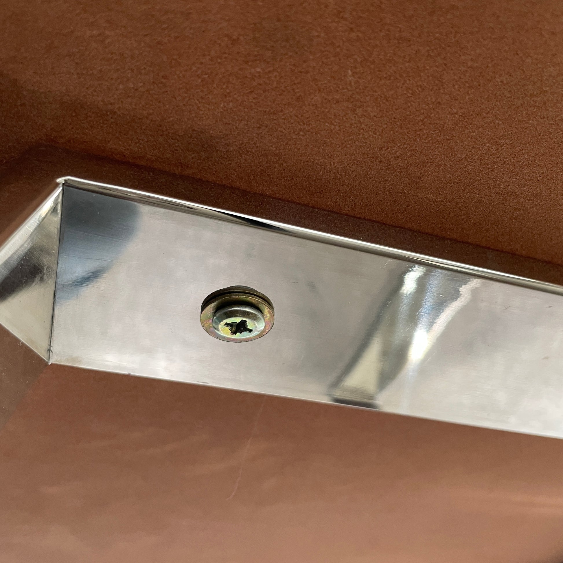 The Lievo Home Modern Studio Ingrid Coffee Table has a glossy marble top with white and gray stripes and a polished stainless steel base, shown on a bare concrete floor against a plain white wall.