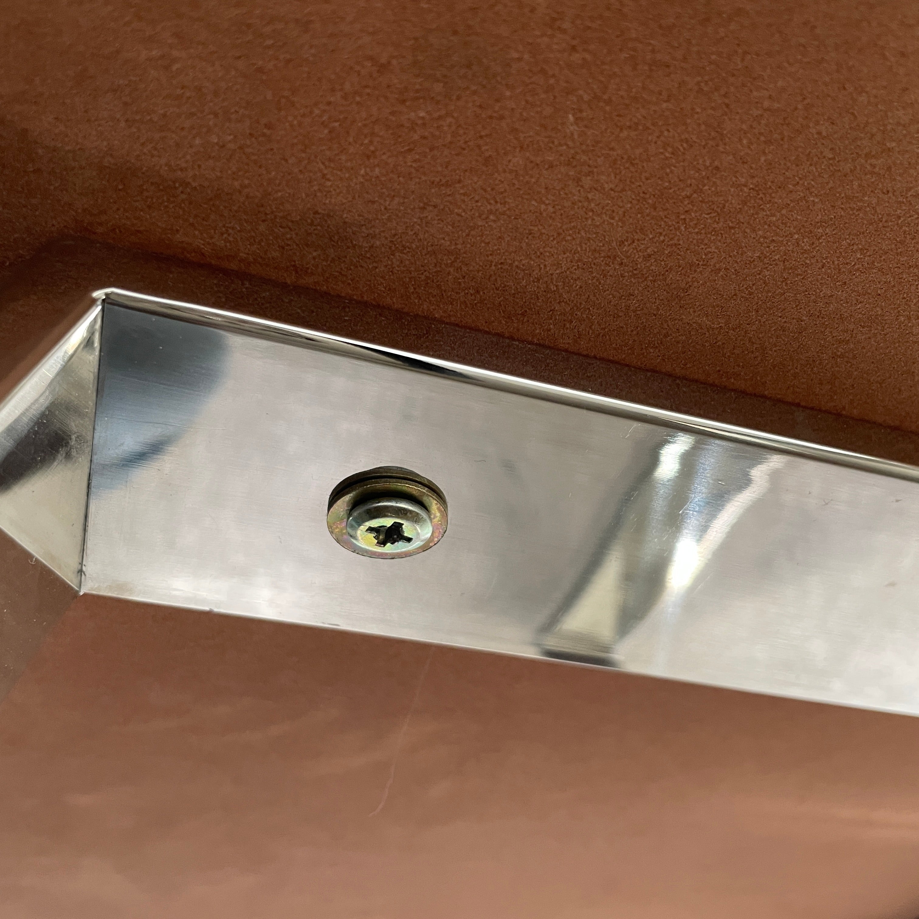 The Lievo Home Modern Studio Ingrid Coffee Table has a glossy marble top with white and gray stripes and a polished stainless steel base, shown on a bare concrete floor against a plain white wall.