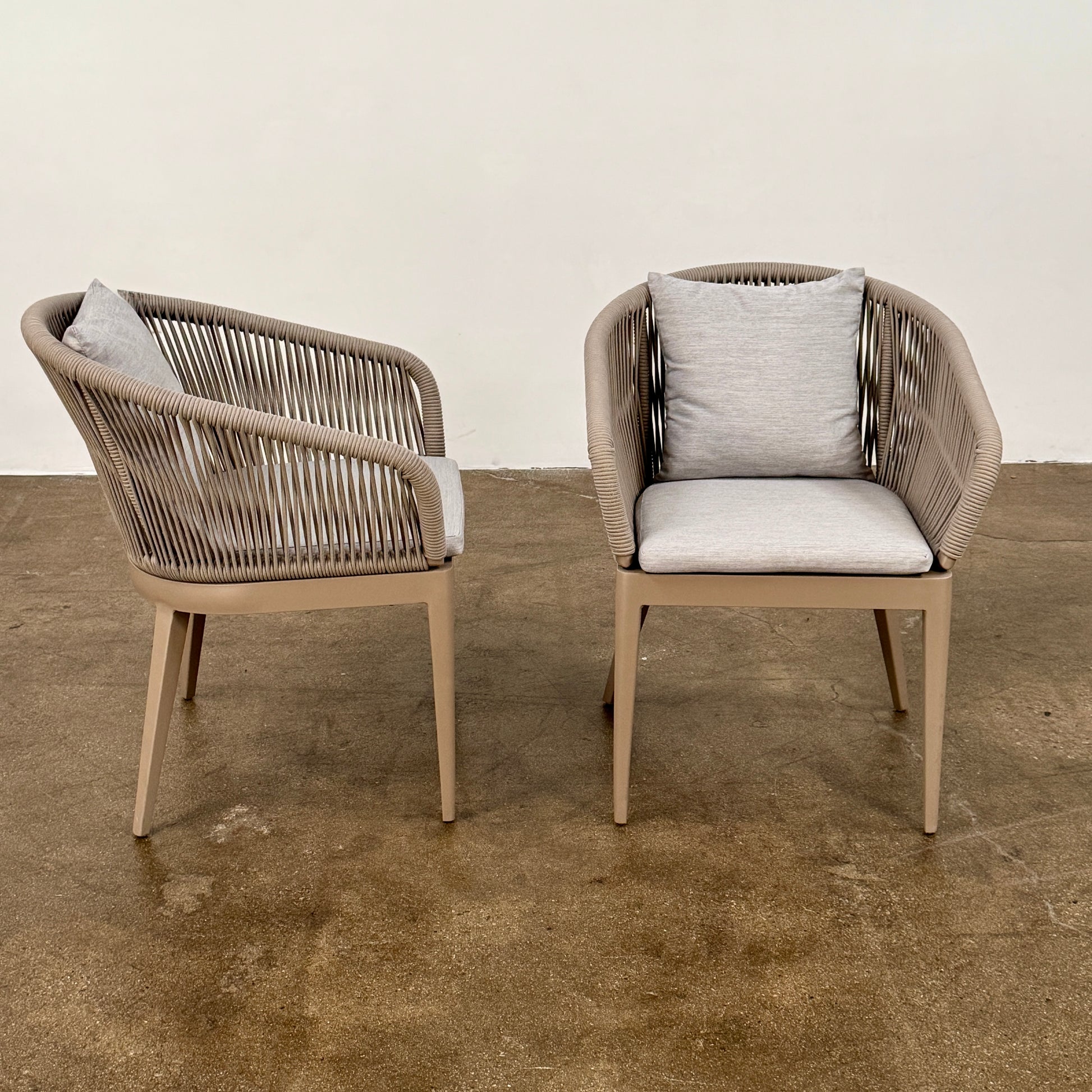 Six Harbour Hamilton Outdoor Dining Chairs by Harbour, featuring a beige woven design with light cushions, are arranged in two rows of three on a plain light background.