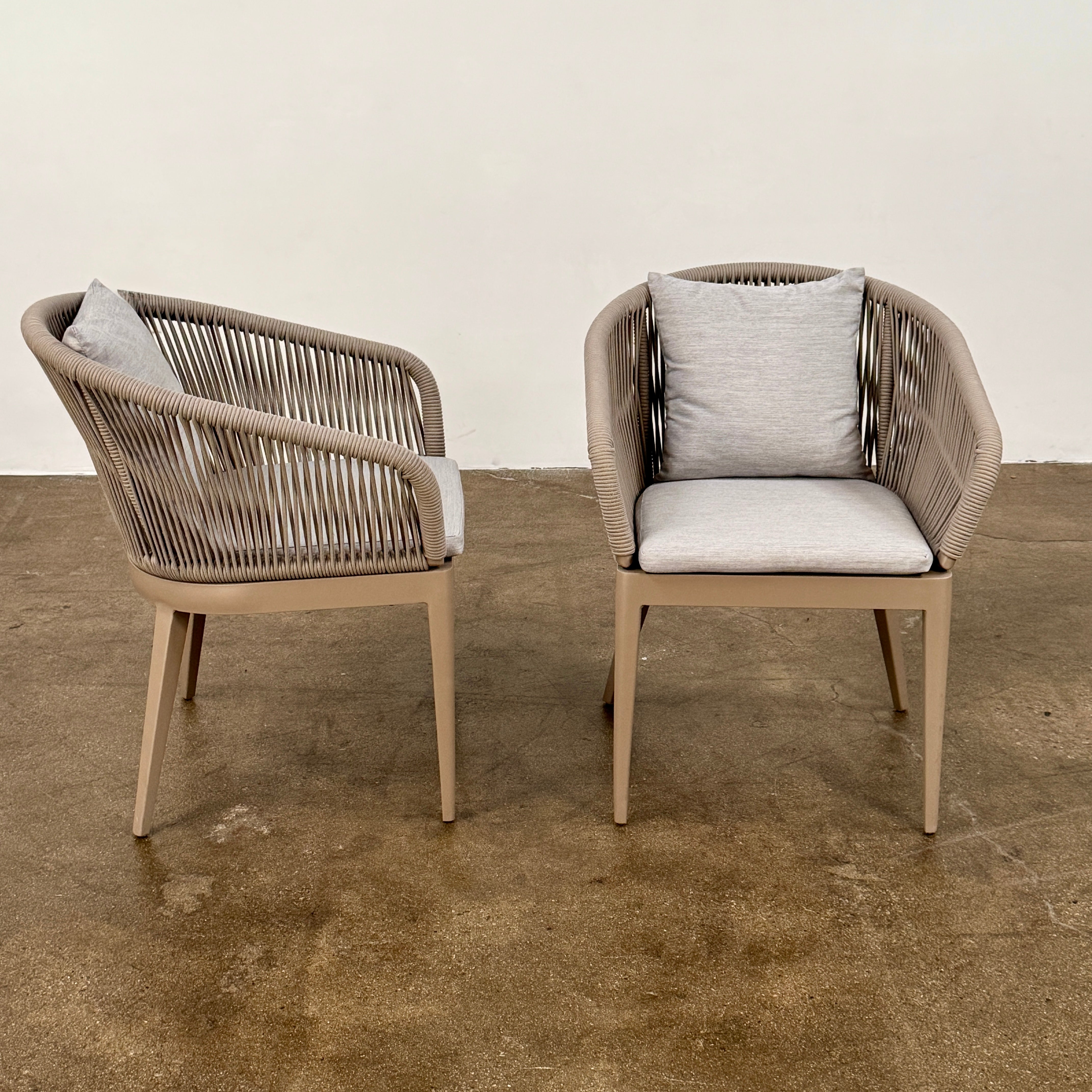 Six Harbour Hamilton Outdoor Dining Chairs by Harbour, featuring a beige woven design with light cushions, are arranged in two rows of three on a plain light background.