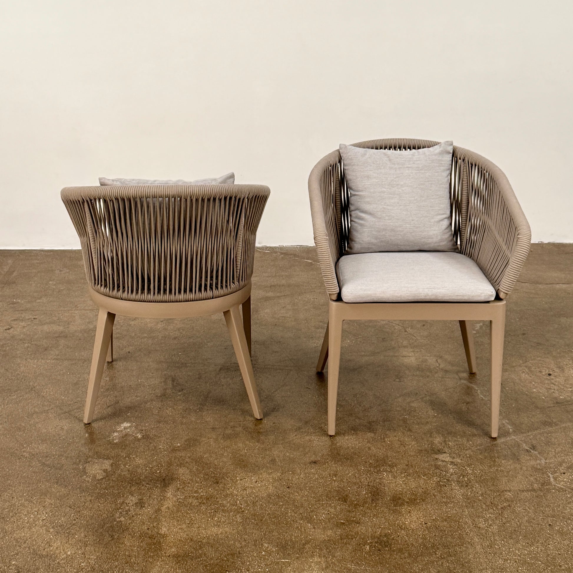 Six Harbour Hamilton Outdoor Dining Chairs by Harbour, featuring a beige woven design with light cushions, are arranged in two rows of three on a plain light background.