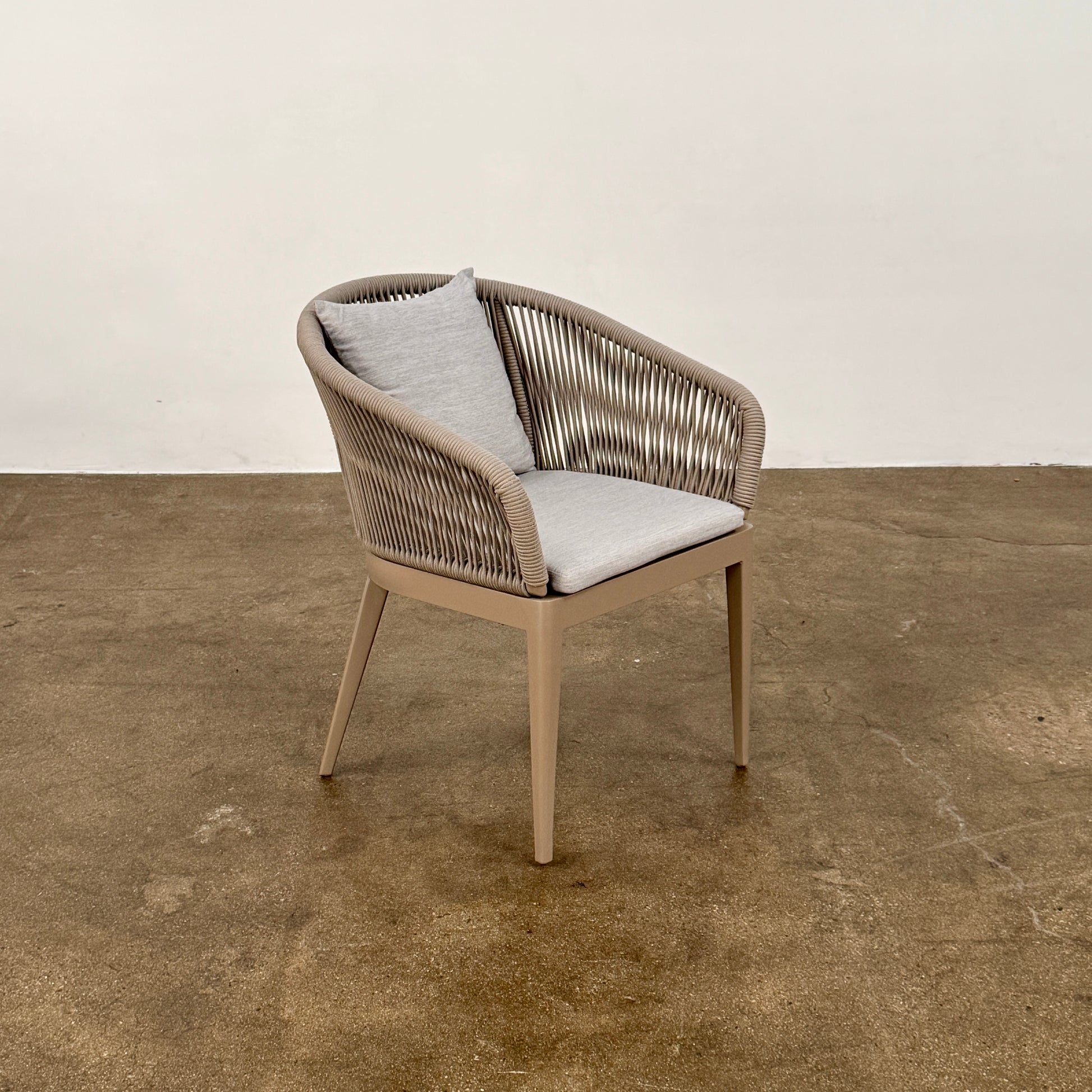 Six Harbour Hamilton Outdoor Dining Chairs by Harbour, featuring a beige woven design with light cushions, are arranged in two rows of three on a plain light background.