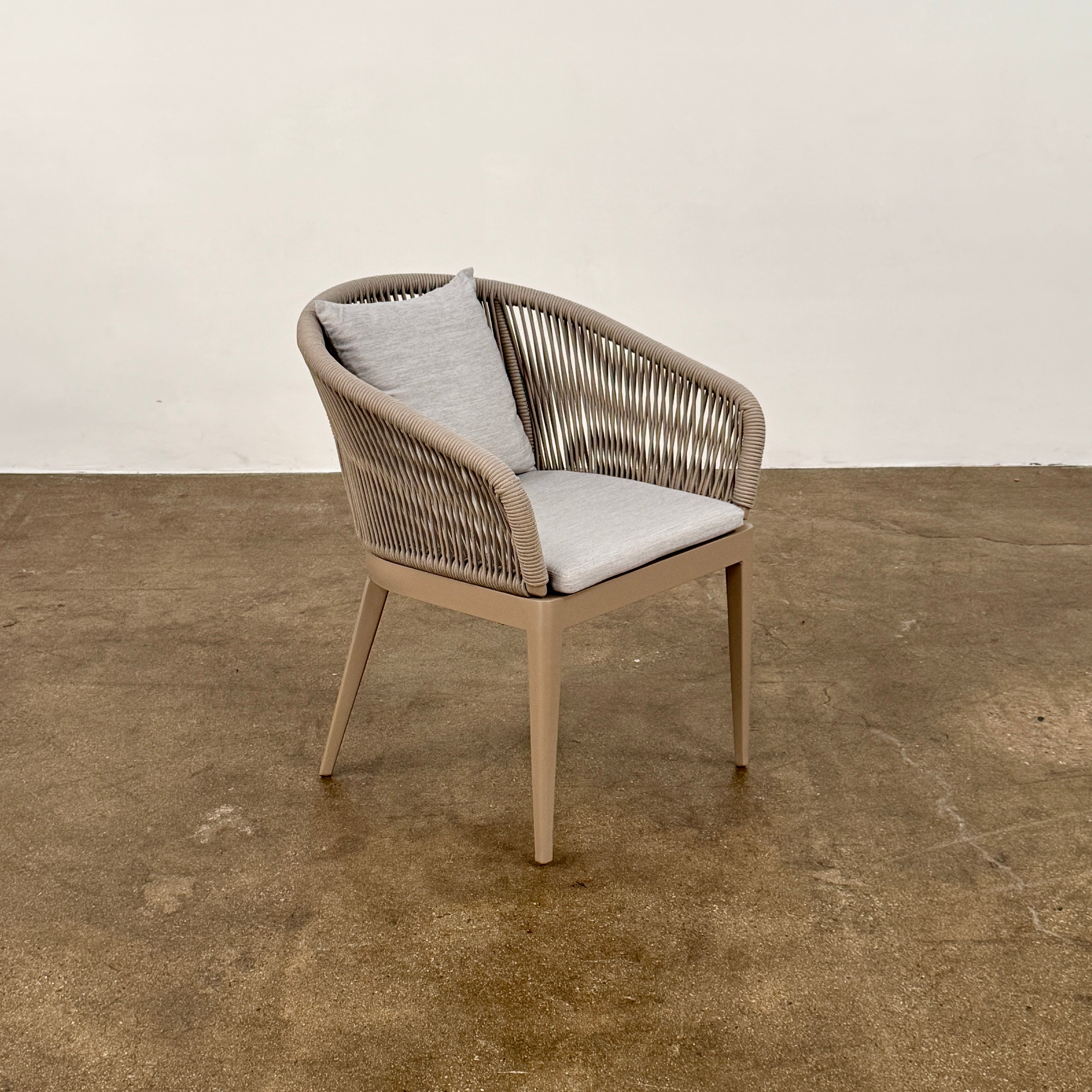 Six Harbour Hamilton Outdoor Dining Chairs by Harbour, featuring a beige woven design with light cushions, are arranged in two rows of three on a plain light background.