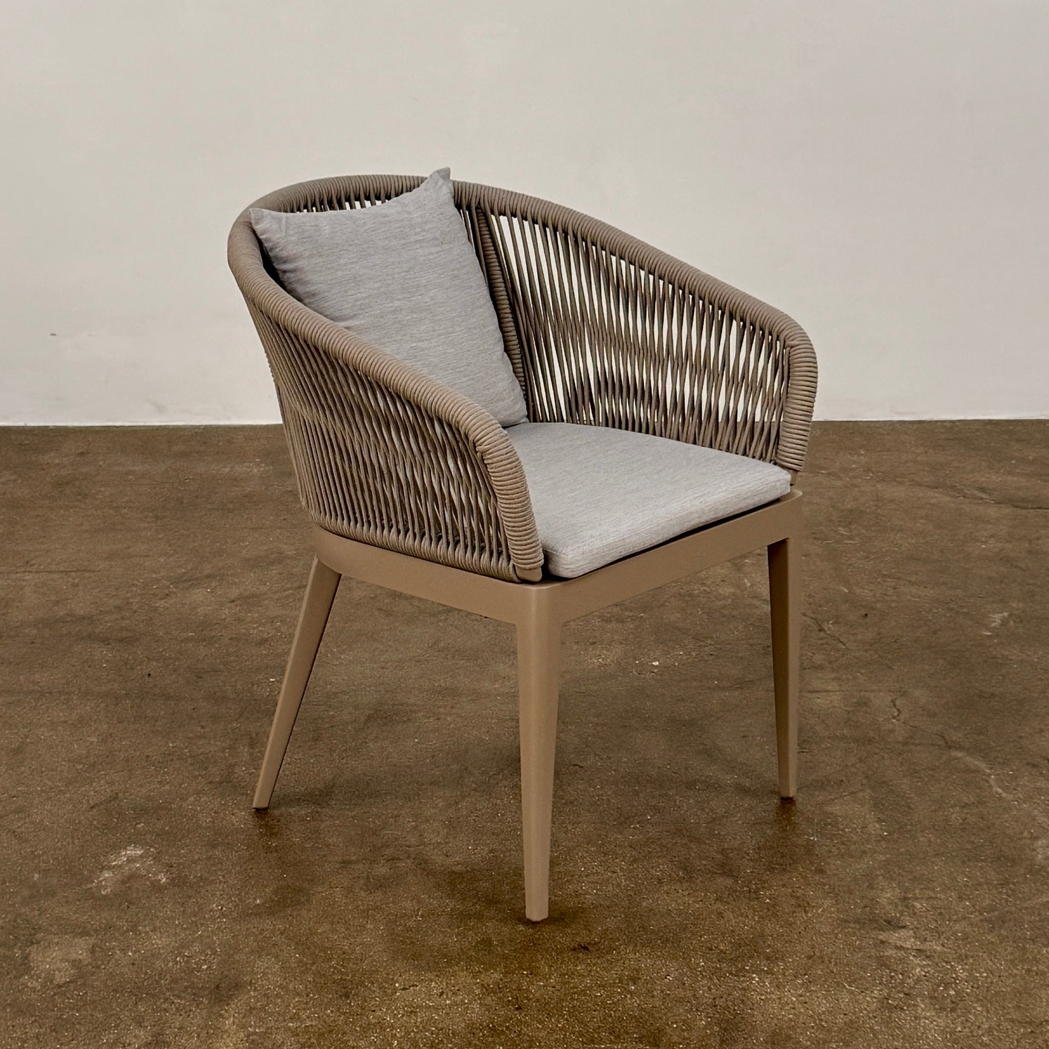 Six Harbour Hamilton Outdoor Dining Chairs by Harbour, featuring a beige woven design with light cushions, are arranged in two rows of three on a plain light background.