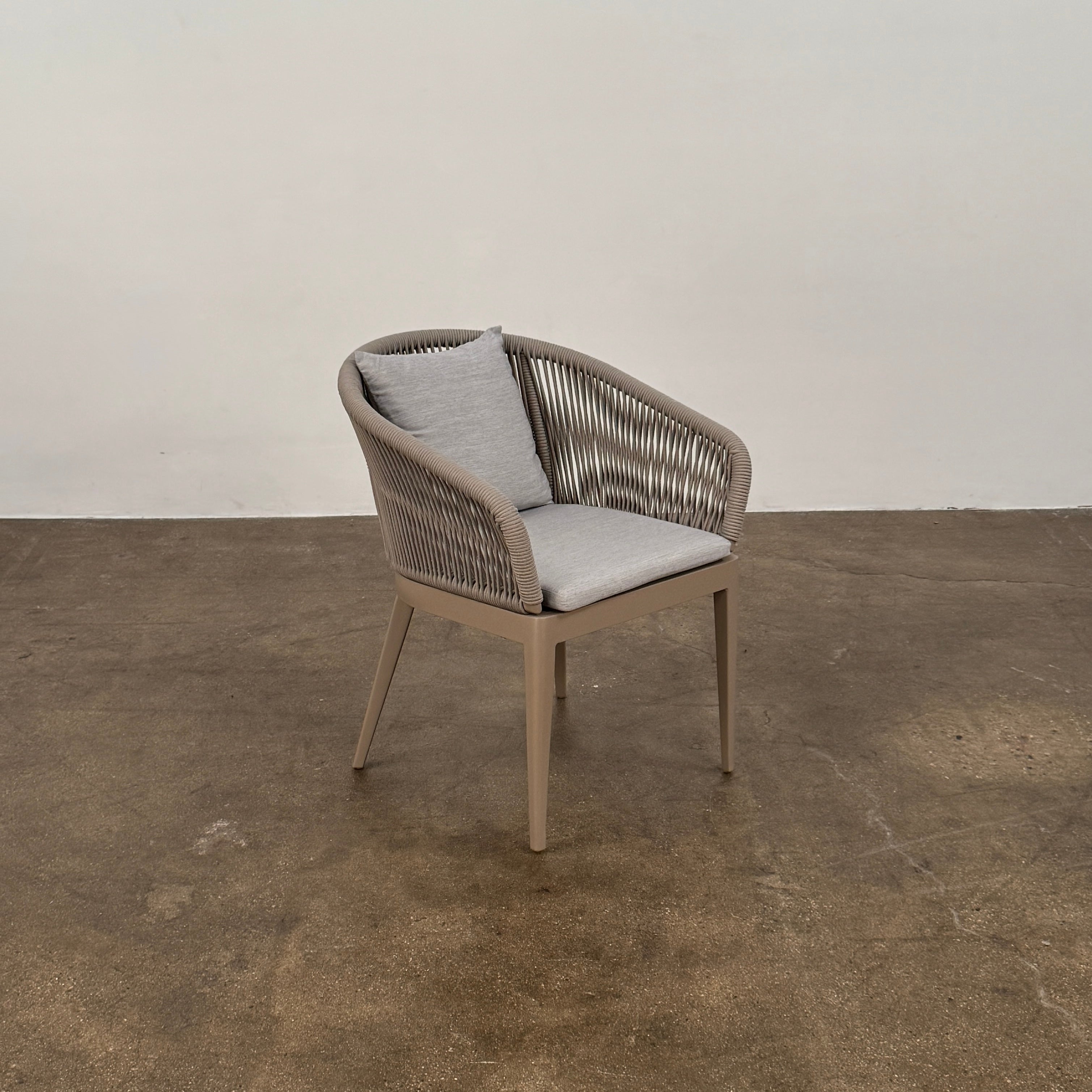 Six Harbour Hamilton Outdoor Dining Chairs by Harbour, featuring a beige woven design with light cushions, are arranged in two rows of three on a plain light background.