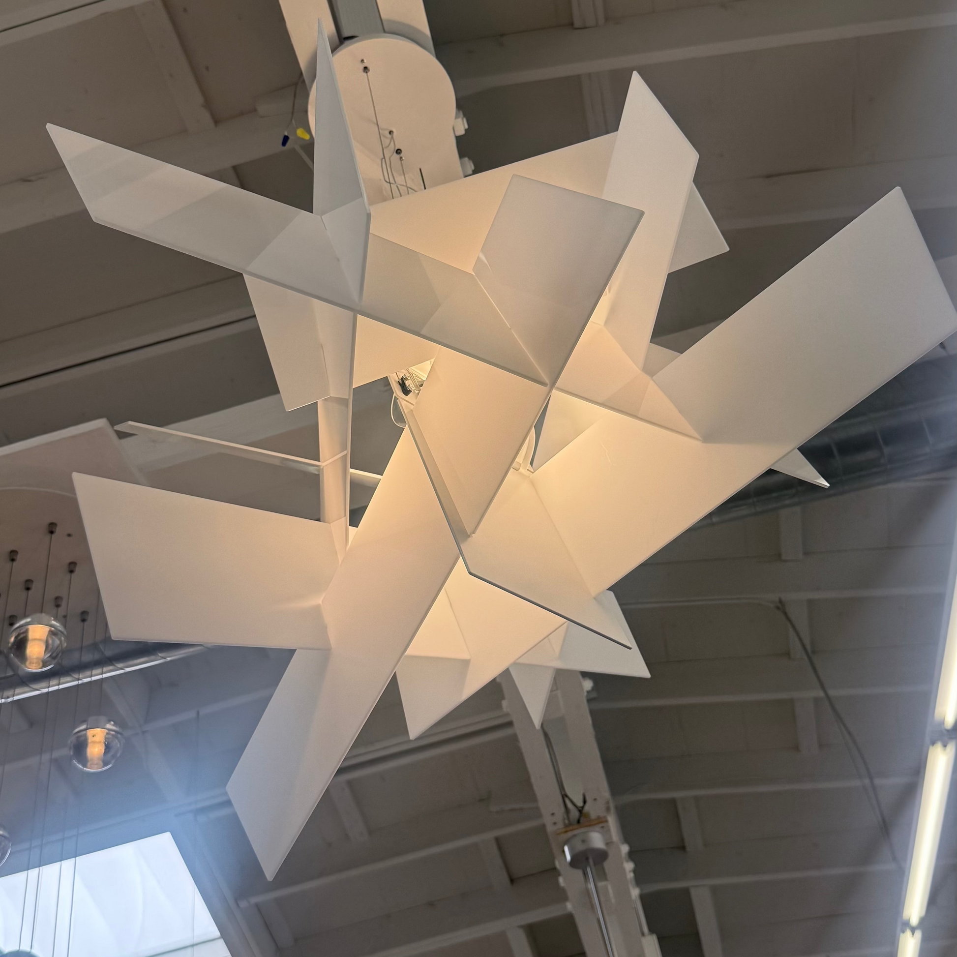 The Foscarini Big Bang LED Pendant, by Foscarini, features sculptural overlapping rectangular panels that emit a warm glow—ideal statement lighting for contemporary spaces.