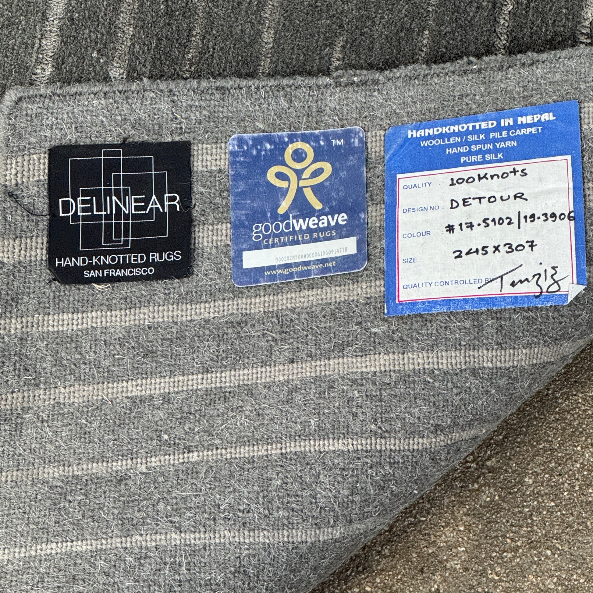 The Delinear Detour Rug 8 x 10 by Delinear features a contemporary rectangular design with a gradient gray pattern and angular geometric lines arranged in a stepped motif.