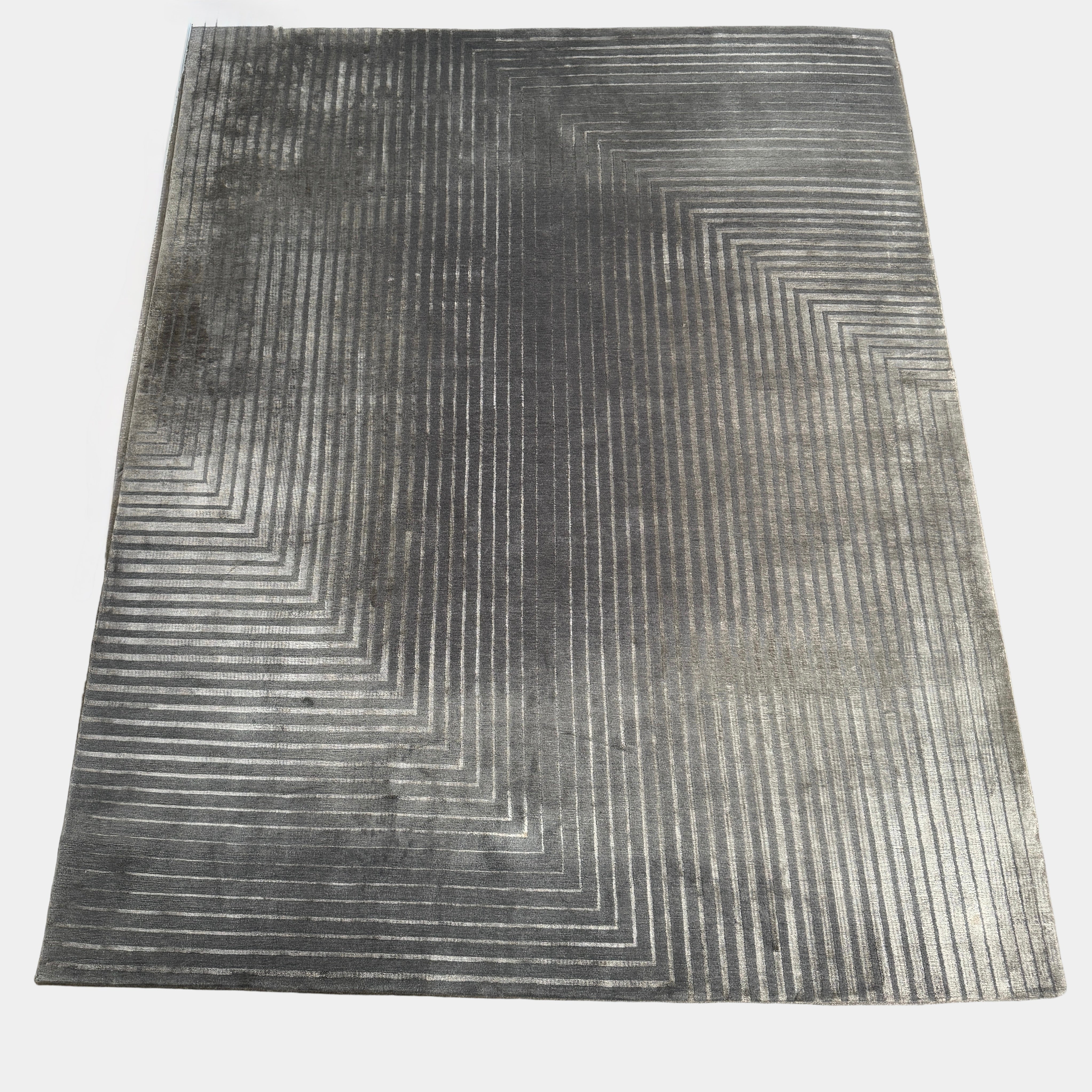 The Delinear Detour Rug 8 x 10 by Delinear features a contemporary rectangular design with a gradient gray pattern and angular geometric lines arranged in a stepped motif.