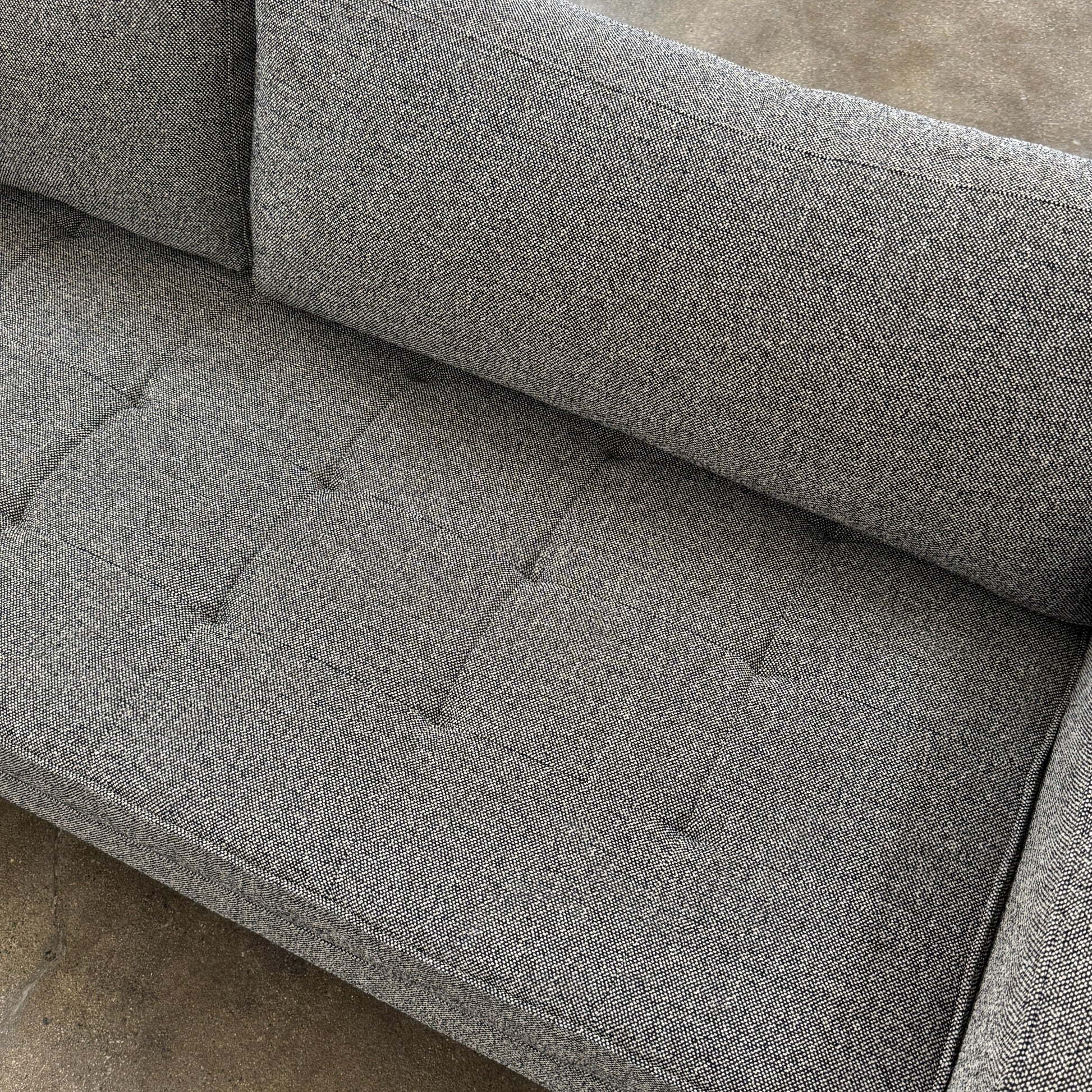 The Blu Dot Paramont Sofa is a grey, three-seater sofa by Blu Dot, featuring metal legs and two back cushions, shown against a plain white background.