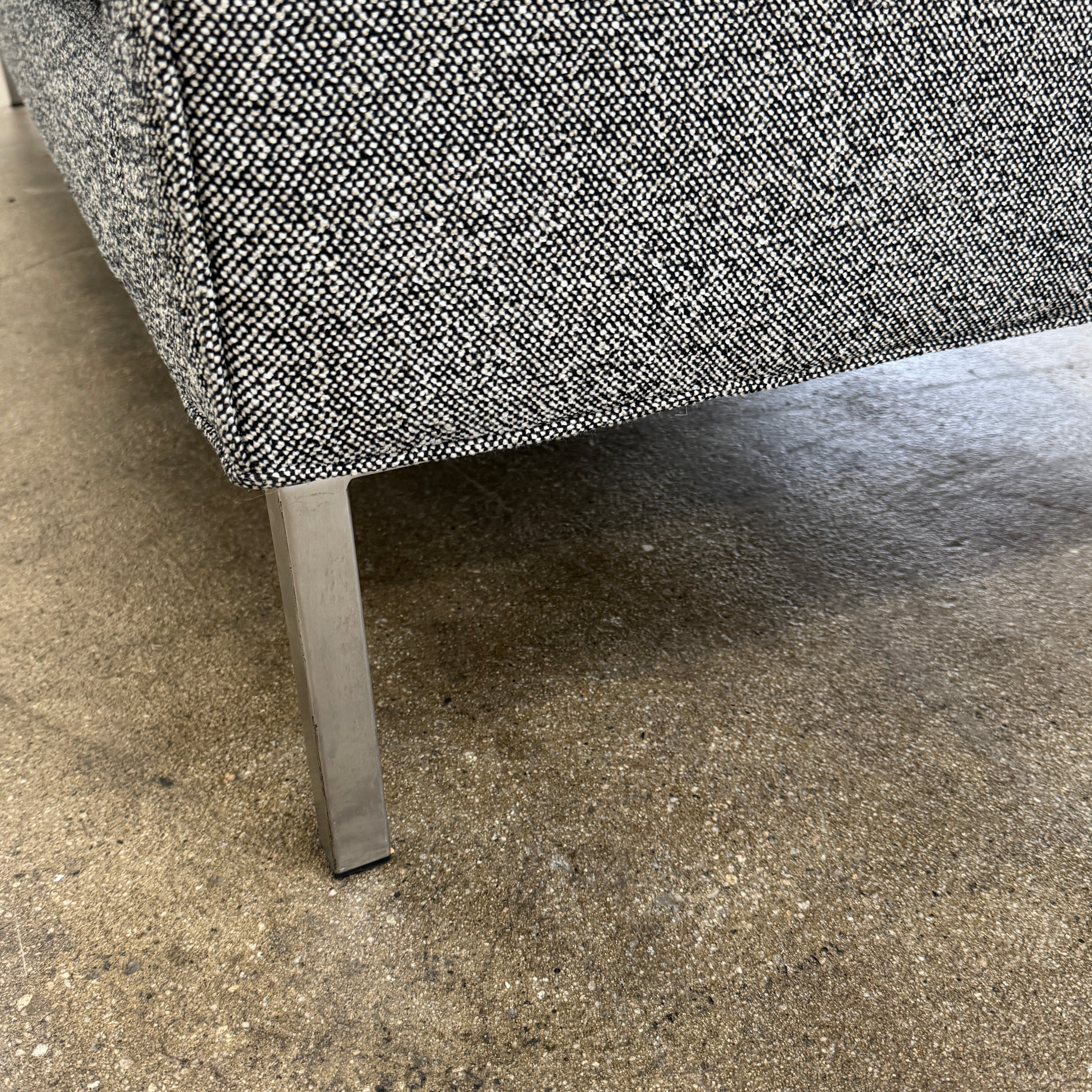 The Blu Dot Paramont Sofa is a grey, three-seater sofa by Blu Dot, featuring metal legs and two back cushions, shown against a plain white background.