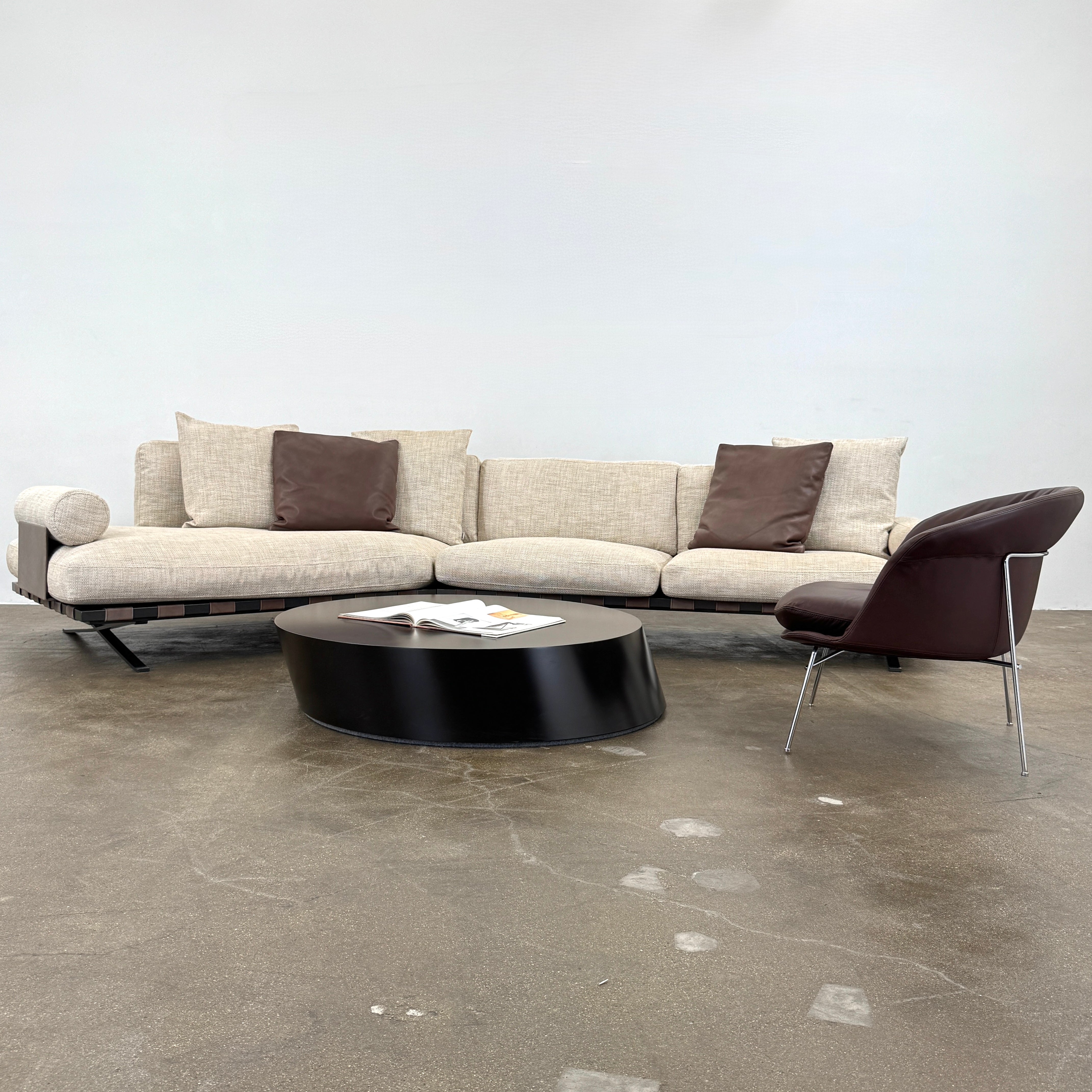 The Driade Moon Lounge Chair by Driade features a modern brown leather design, curved backrest, and slim metal legs, shown against a plain white background.