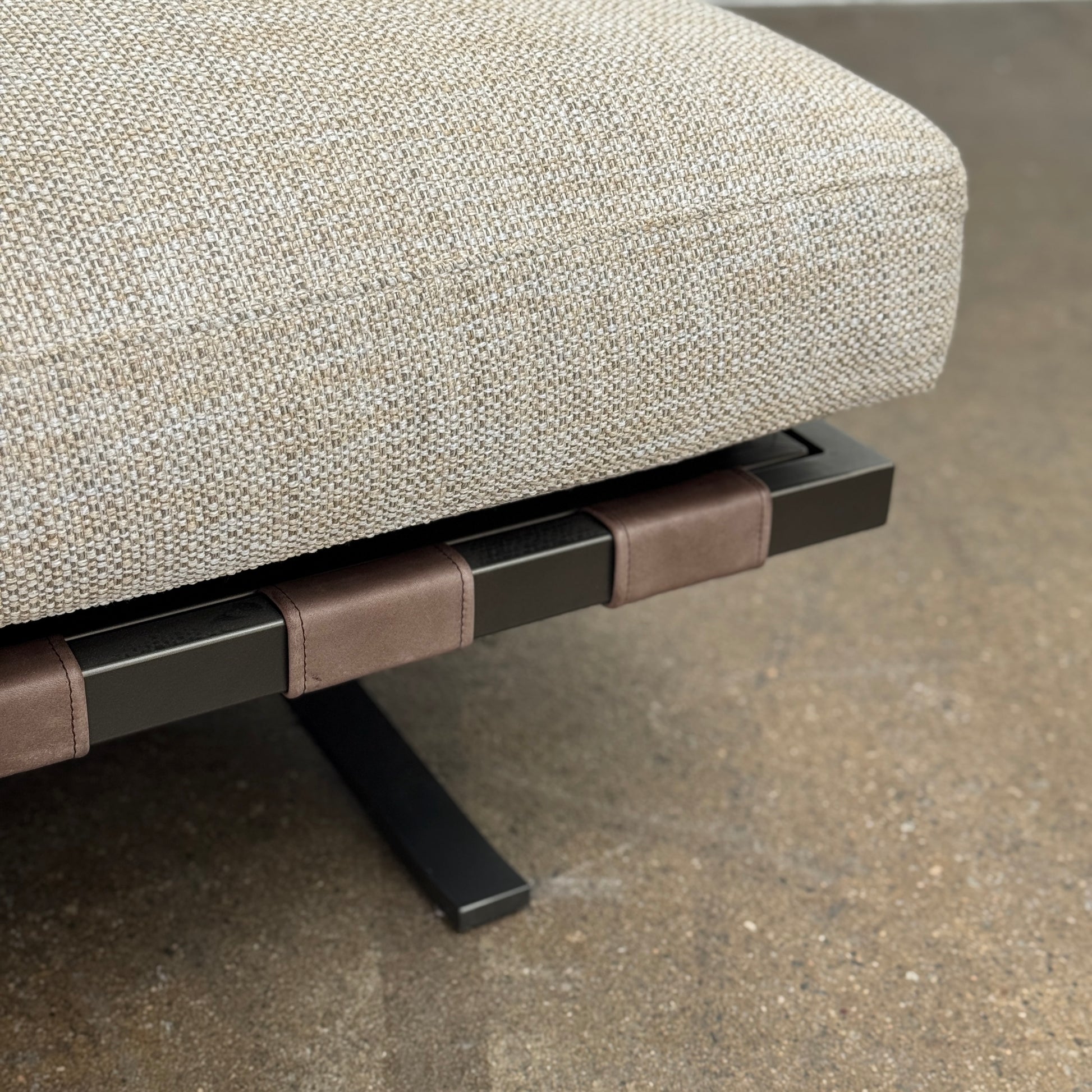 The Driade Fenix sofa by Driade is a beige L-shaped modular design with three seat cushions, black legs, and four throw pillows—two brown, two beige—highlighting its architectural lightness against a plain white backdrop.