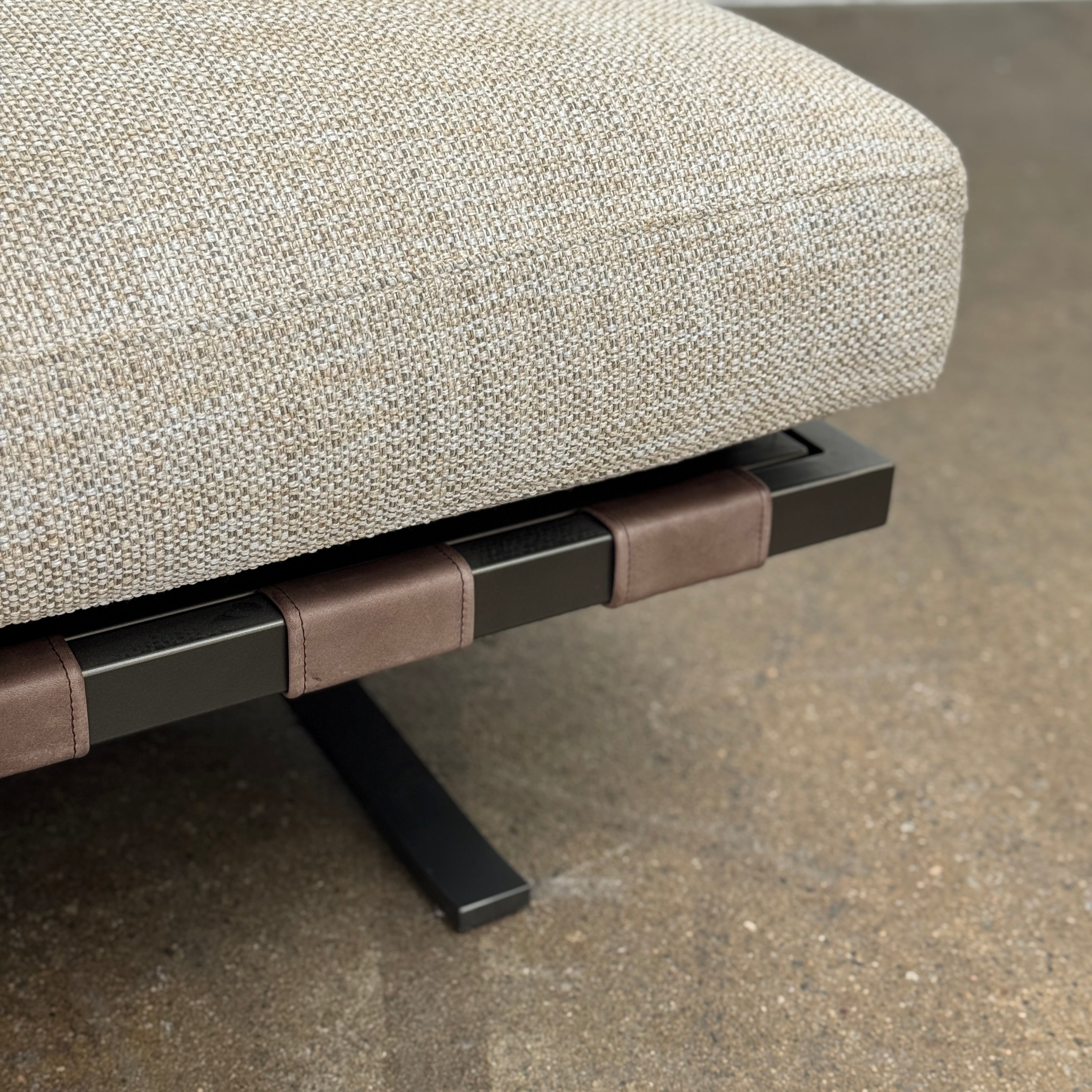 The Driade Fenix sofa by Driade is a beige L-shaped modular design with three seat cushions, black legs, and four throw pillows—two brown, two beige—highlighting its architectural lightness against a plain white backdrop.