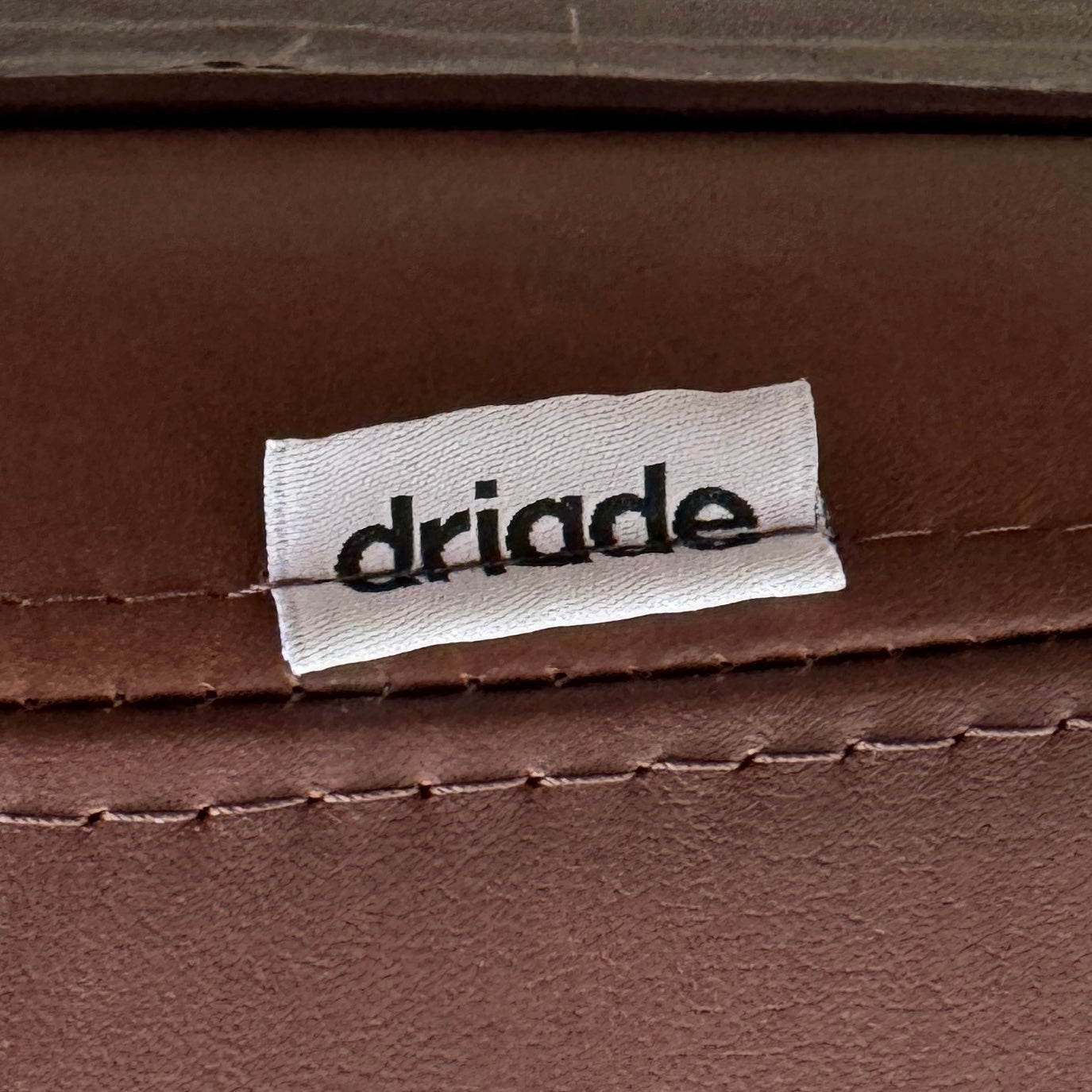 The Driade Moon Lounge Chair by Driade features a modern brown leather design, curved backrest, and slim metal legs, shown against a plain white background.