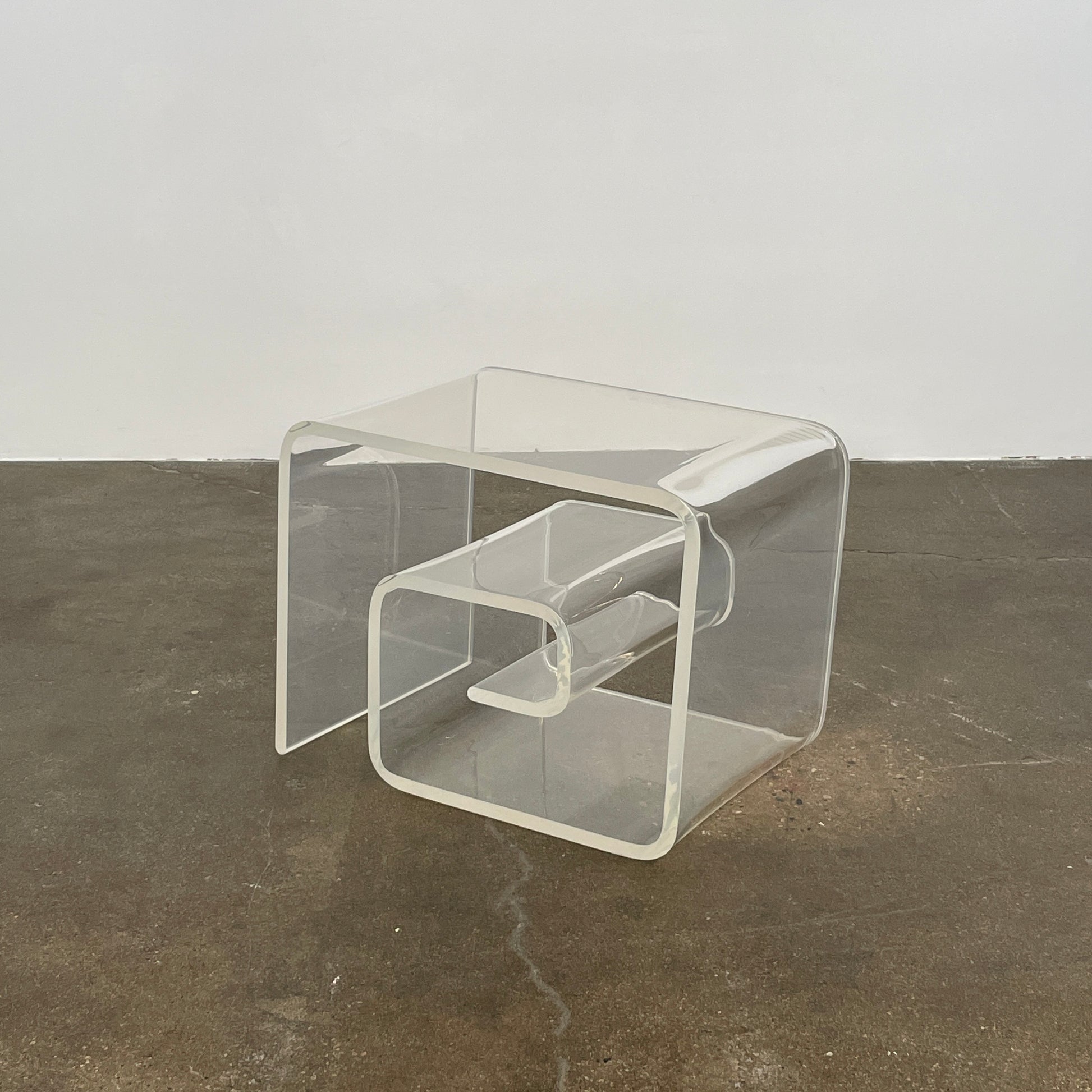 The Vintage Modern Lucite Scroll Accent Table features a clear, sculptural design—an iconic 1960s/70s piece that brings retro charm and modern style to any space.