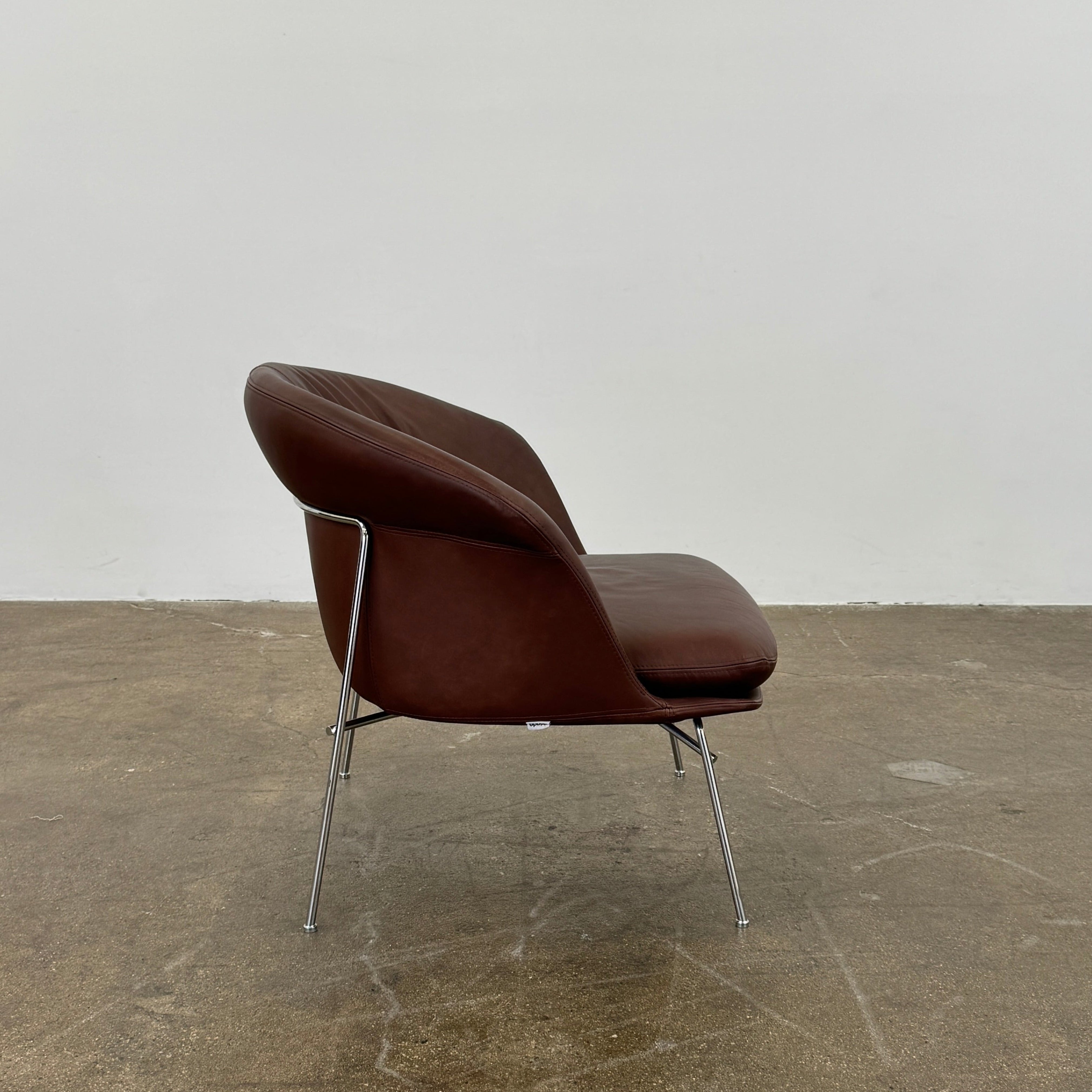 The Driade Moon Lounge Chair by Driade features a modern brown leather design, curved backrest, and slim metal legs, shown against a plain white background.