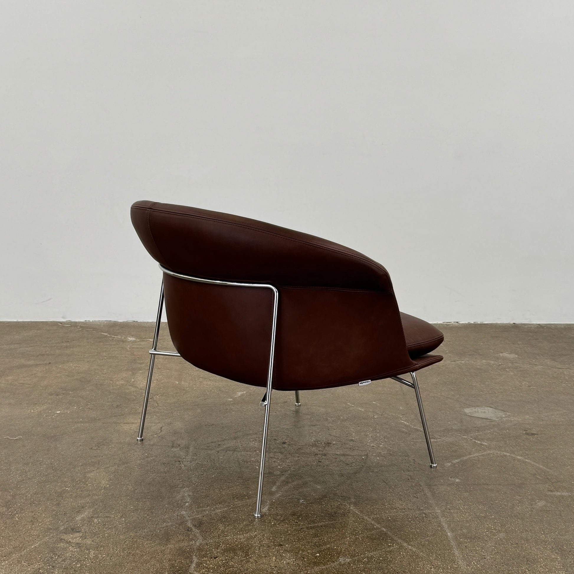 The Driade Moon Lounge Chair by Driade features a modern brown leather design, curved backrest, and slim metal legs, shown against a plain white background.