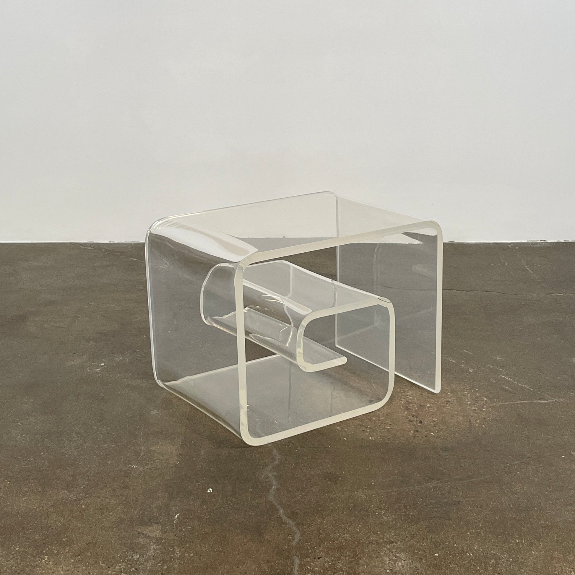 The Vintage Modern Lucite Scroll Accent Table features a clear, sculptural design—an iconic 1960s/70s piece that brings retro charm and modern style to any space.