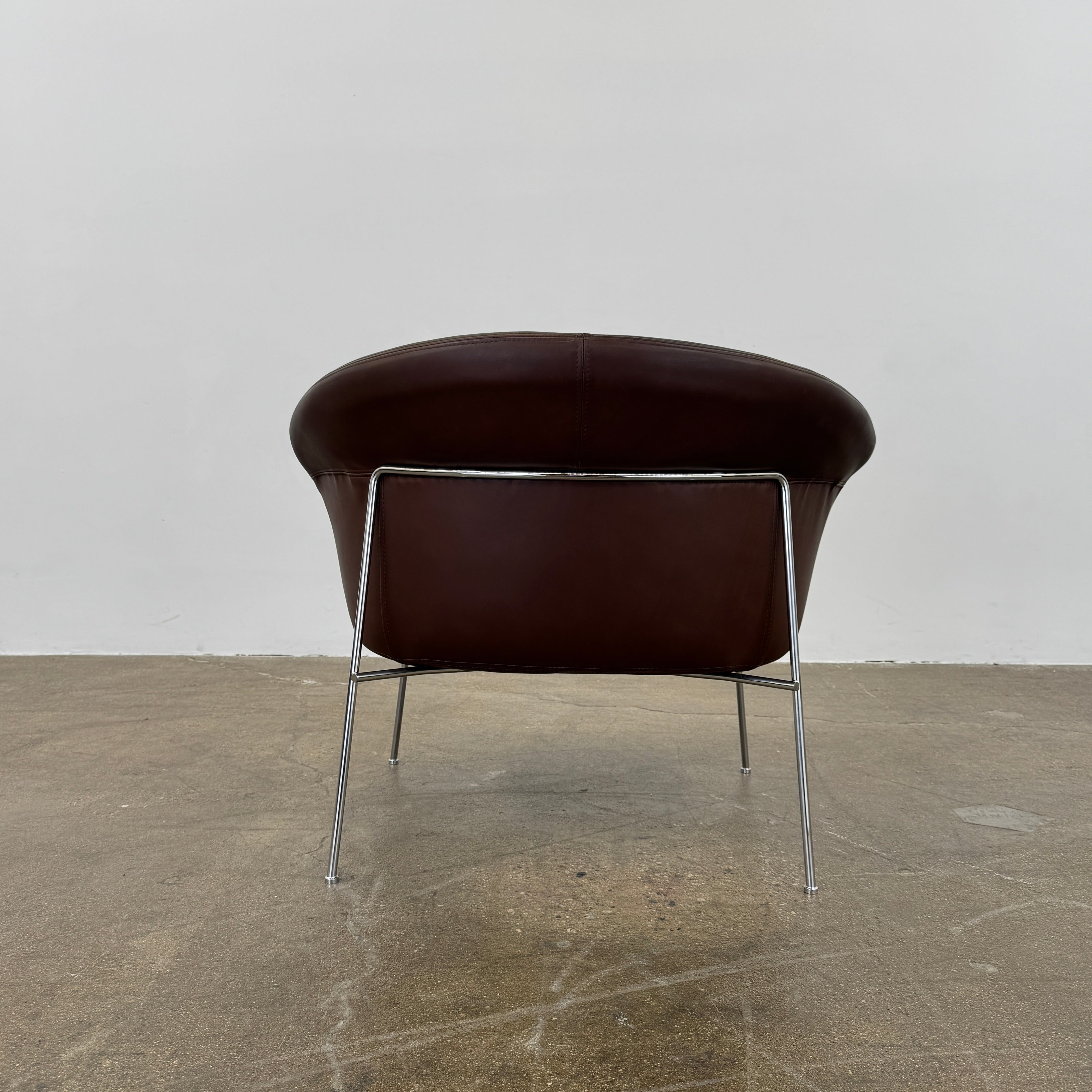 The Driade Moon Lounge Chair by Driade features a modern brown leather design, curved backrest, and slim metal legs, shown against a plain white background.