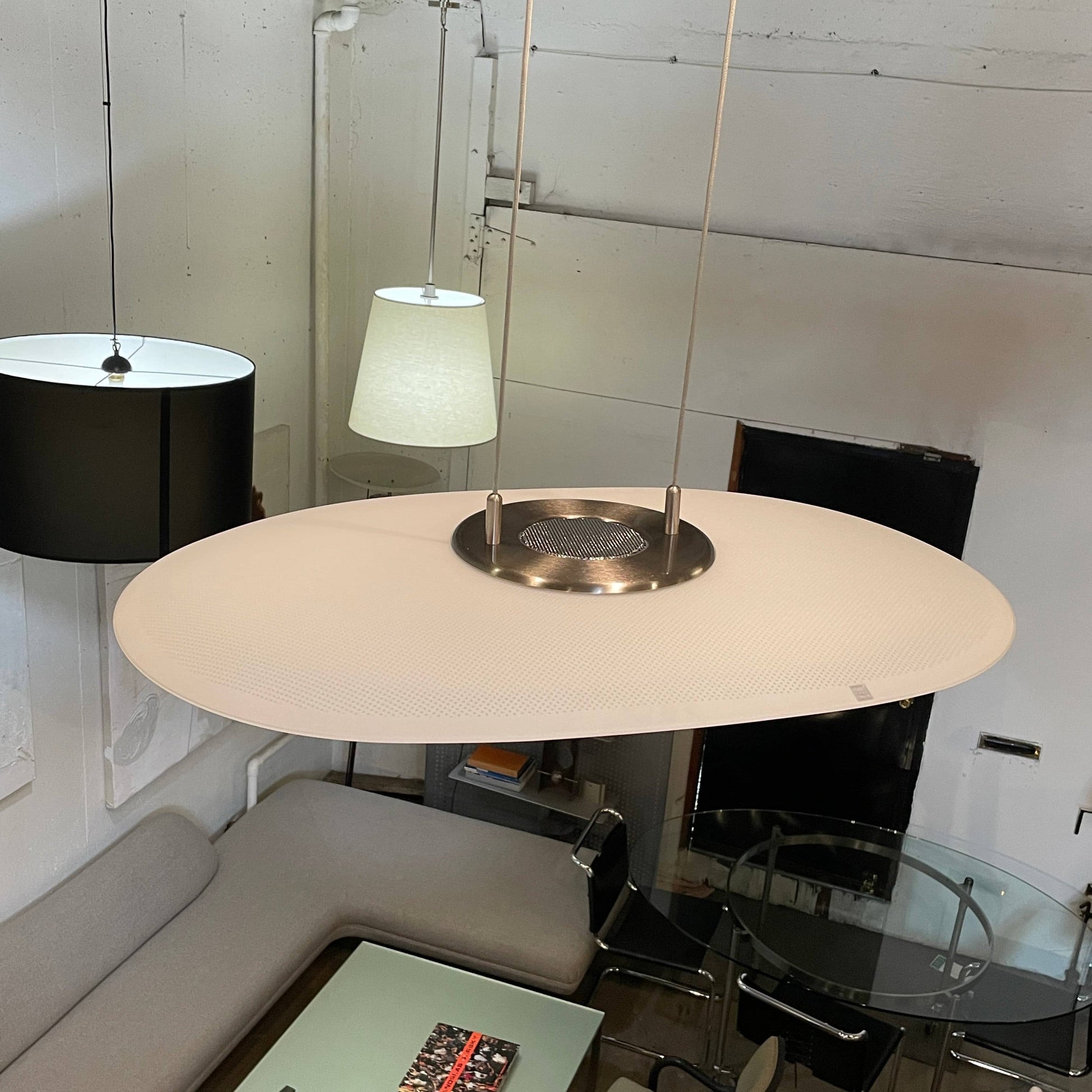 Modern pendant light with a minimalist design, suspended from a metallic base by two cables, the Studio Design Italia Rondo SO Ceiling Light.