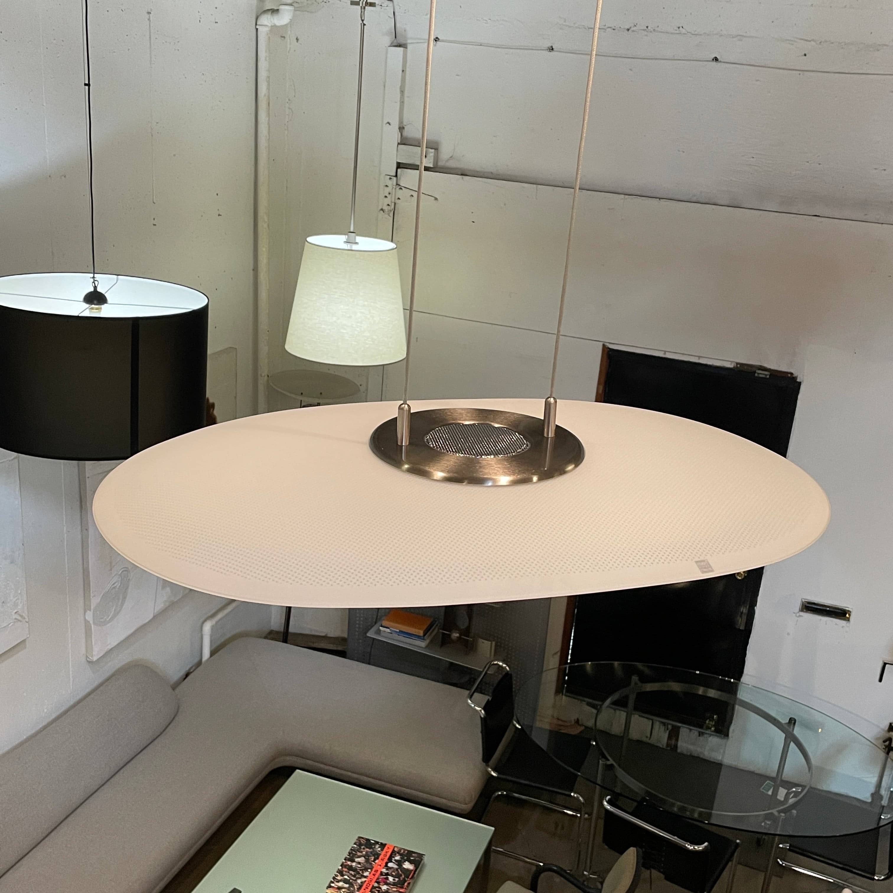 Modern pendant light with a minimalist design, suspended from a metallic base by two cables, the Studio Design Italia Rondo SO Ceiling Light.