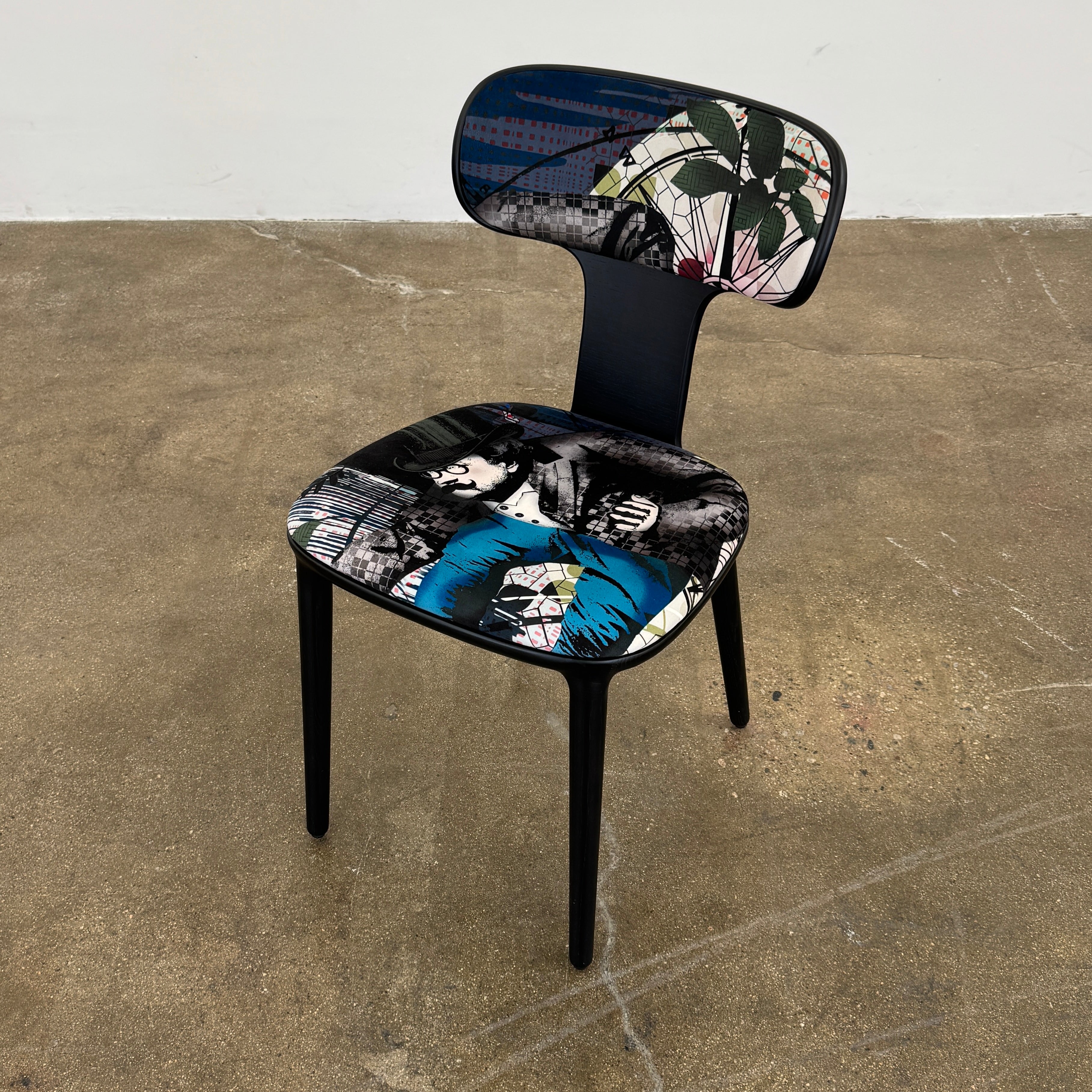 A set of six black Roche Bobois Globe Trotter Operette dining chairs, featuring patterned cushions and backs, arranged in two rows against a plain white background.