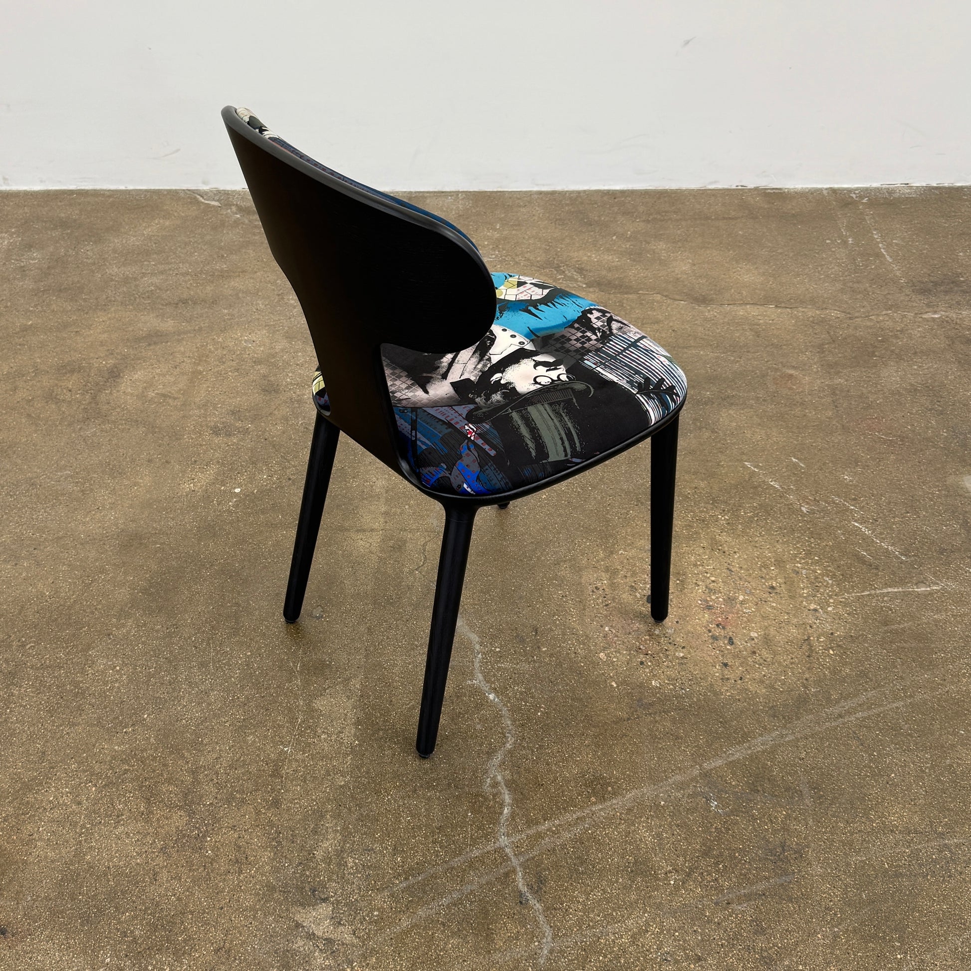 A set of six black Roche Bobois Globe Trotter Operette dining chairs, featuring patterned cushions and backs, arranged in two rows against a plain white background.